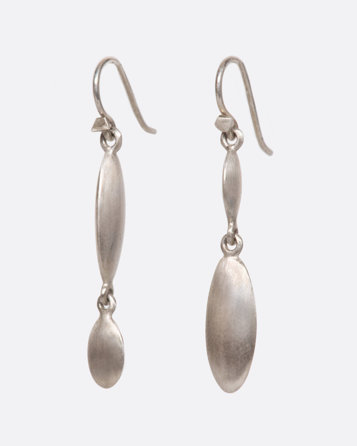 These asymmetrical dangles juxtapose a flat circle with a razor-thin oval in a luscious matte finish