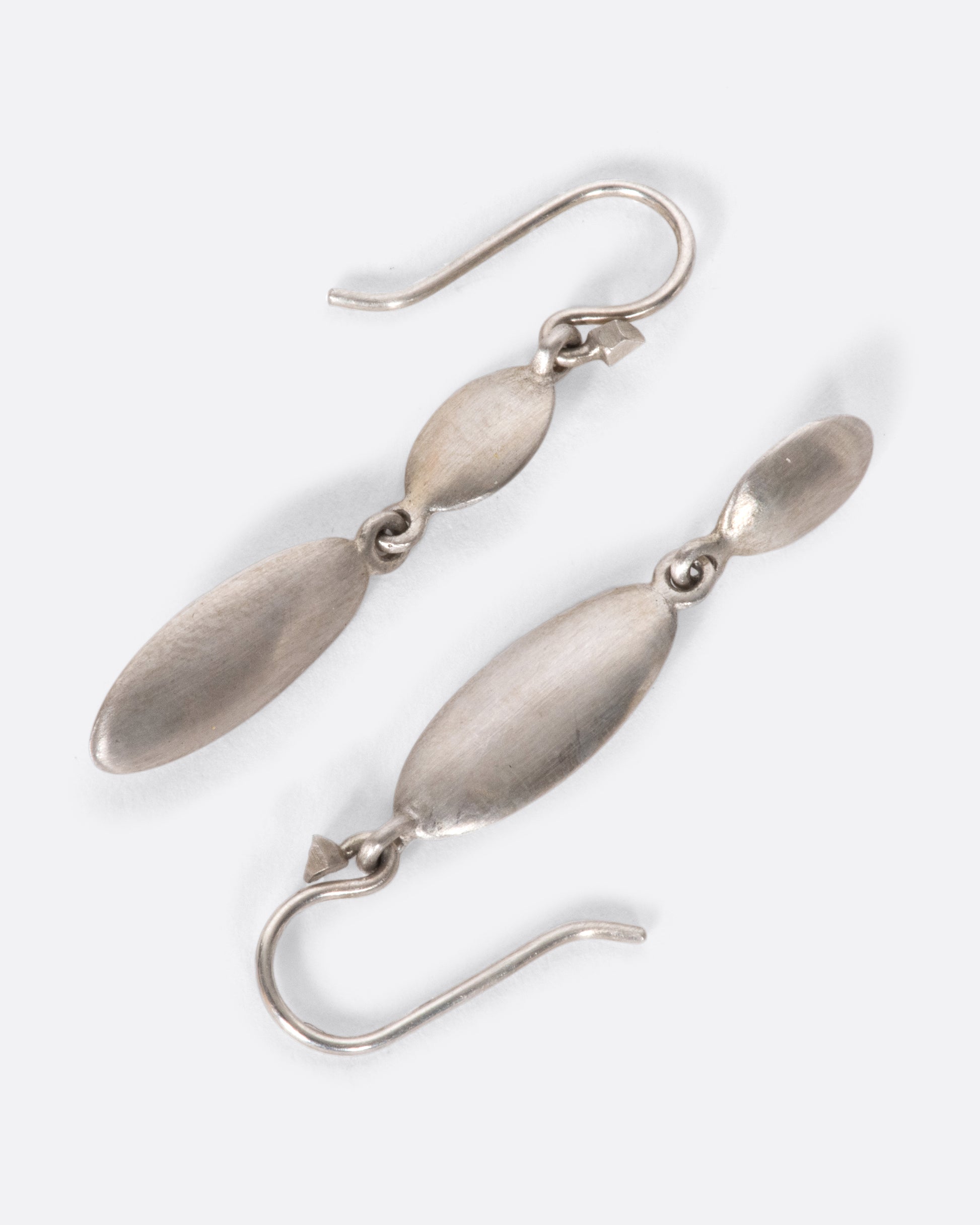 These asymmetrical dangles juxtapose a flat circle with a razor-thin oval in a luscious matte finish