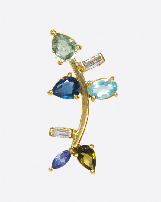 This elegant 14k gold stud, dotted with blue and green gemstones, reminds us of an olive branch