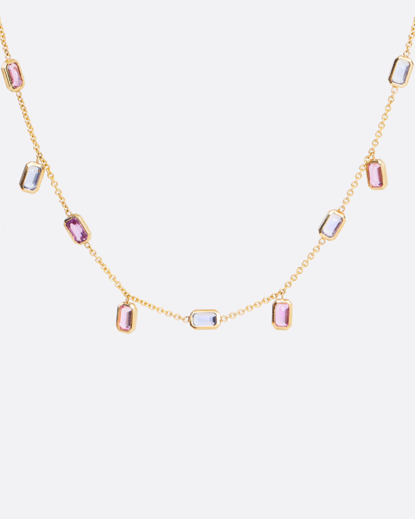 A chain necklace with alternating fixed and floating bezel set sapphires. With a mix of sapphire colors this necklace is fun with a touch of elegant.