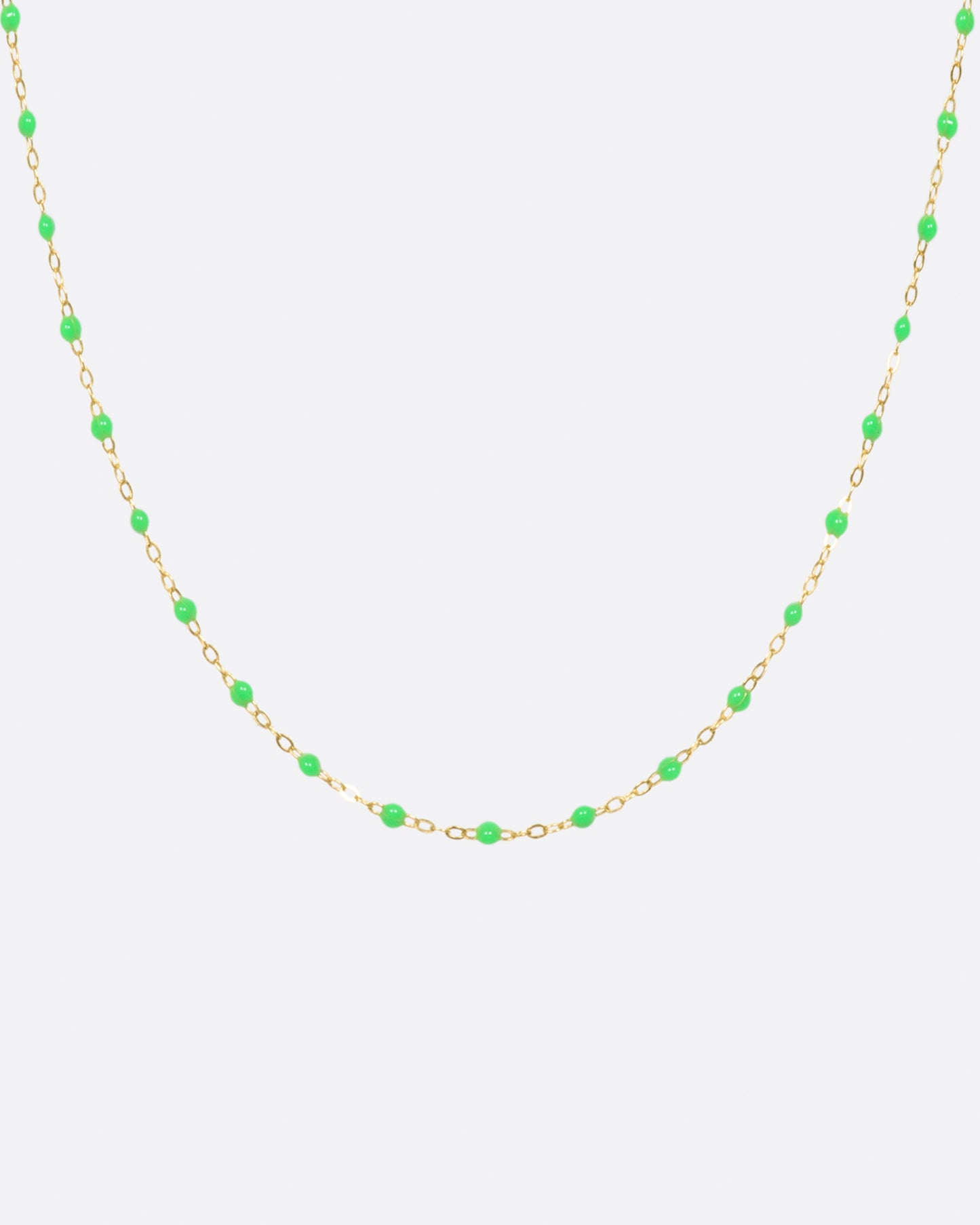 A thin yellow gold chain necklace with resin beads. Each necklace is hand dipped in melted resin to create the beaded effect.