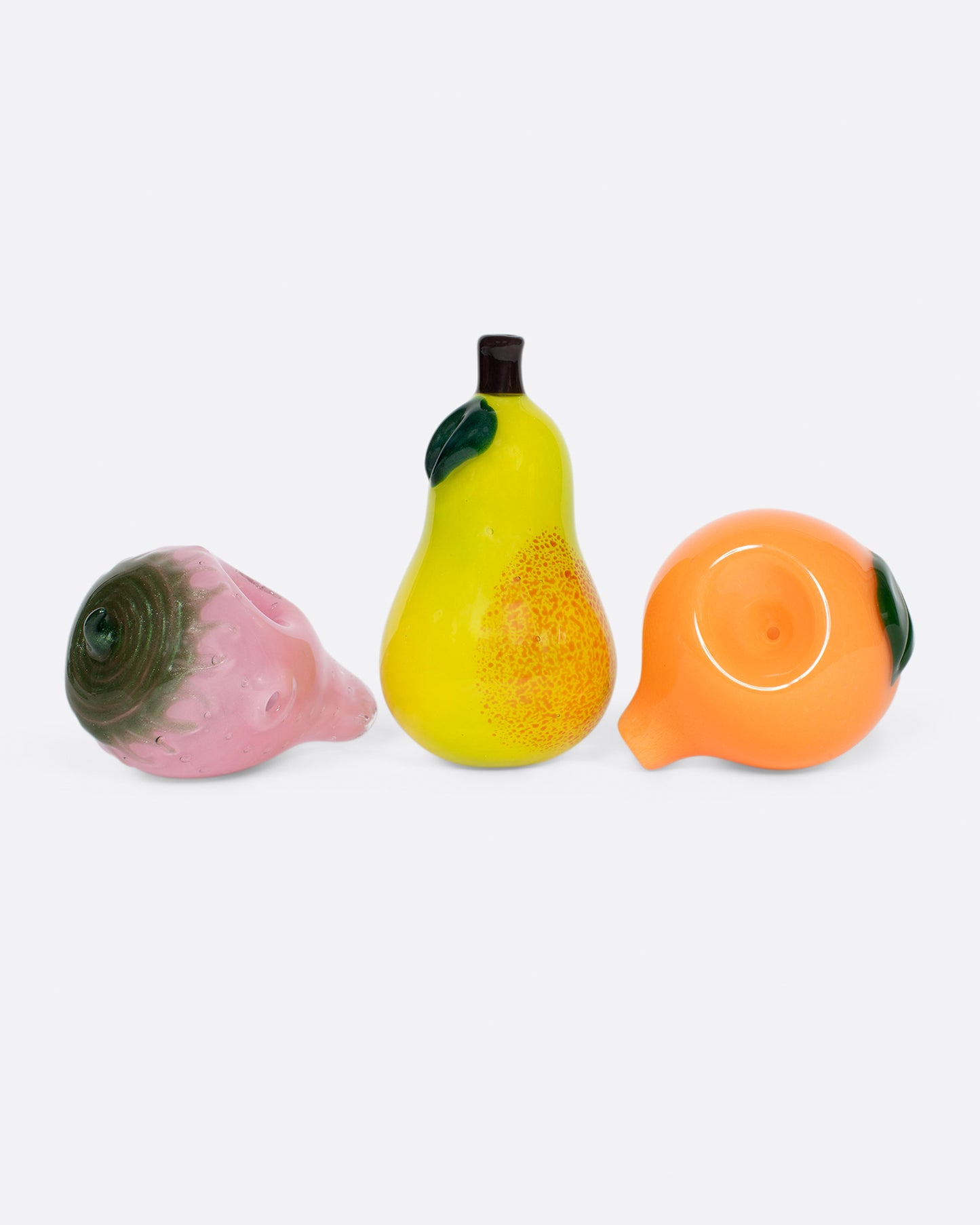 A group of three glass fruit pipes.