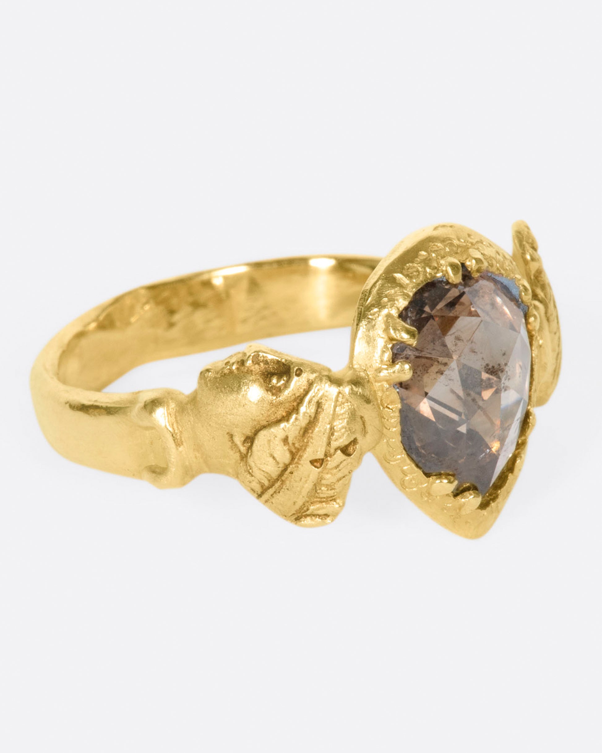 This moody pear-shaped cognac diamond, swirling with chocolaty hues, in an open-back setting that invites light to reflect intensely. The hand-carved bezel and band give a deeply storied feel as if this were dug up in the desert—treasure left behind by an ancient Roman civilization.