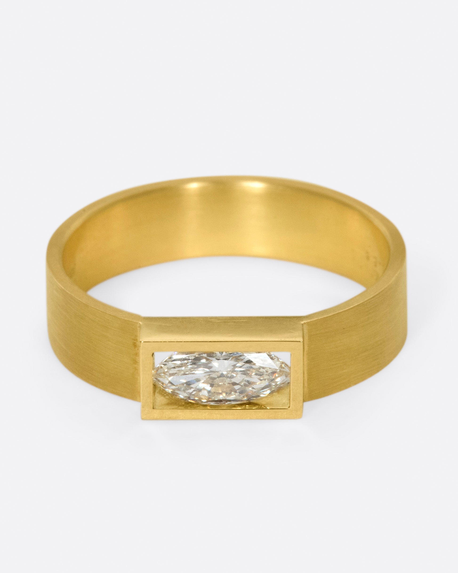 A matte band with marquise diamond set east-west at its center.