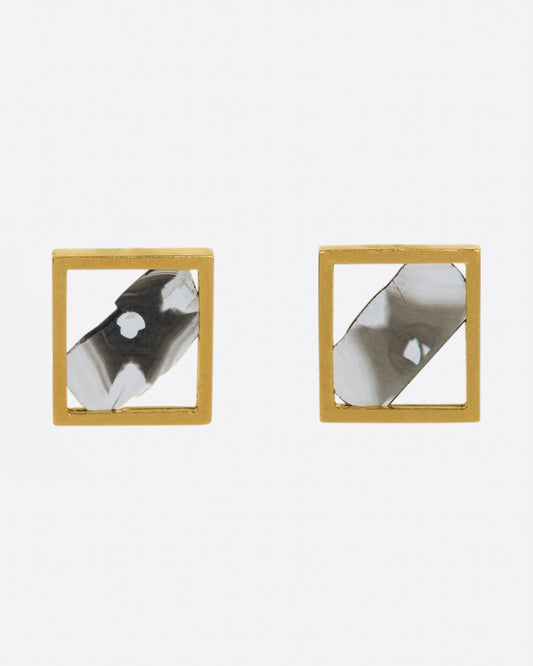 A pair of yellow gold square frame stud earrings, each with a salt & pepper diamond slice set diagonally through it.