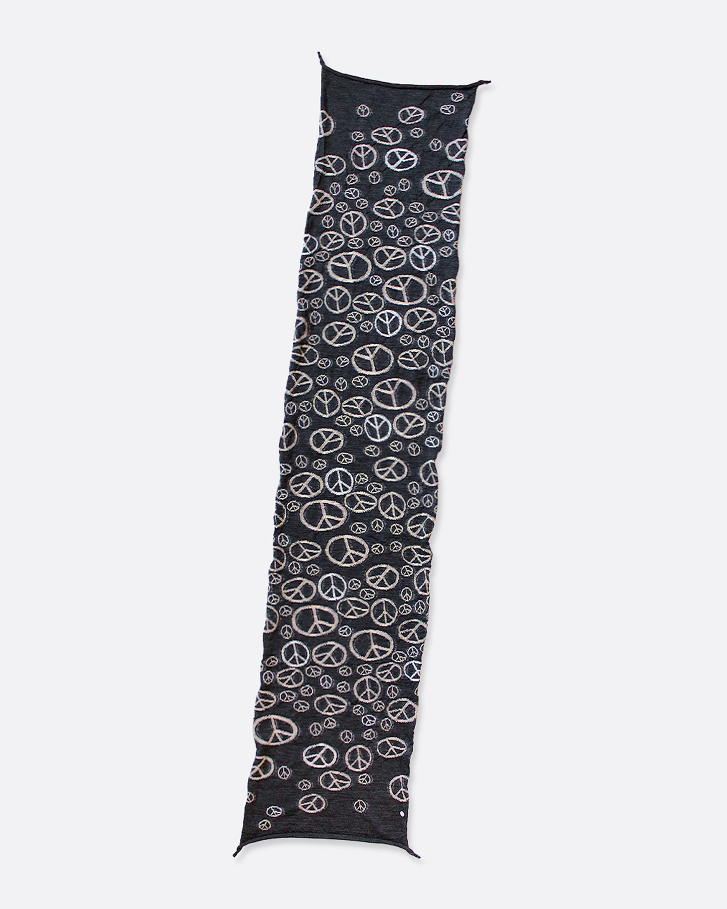 A black compressed wool scarf with a pattern of white peace signs, shown lying flat.