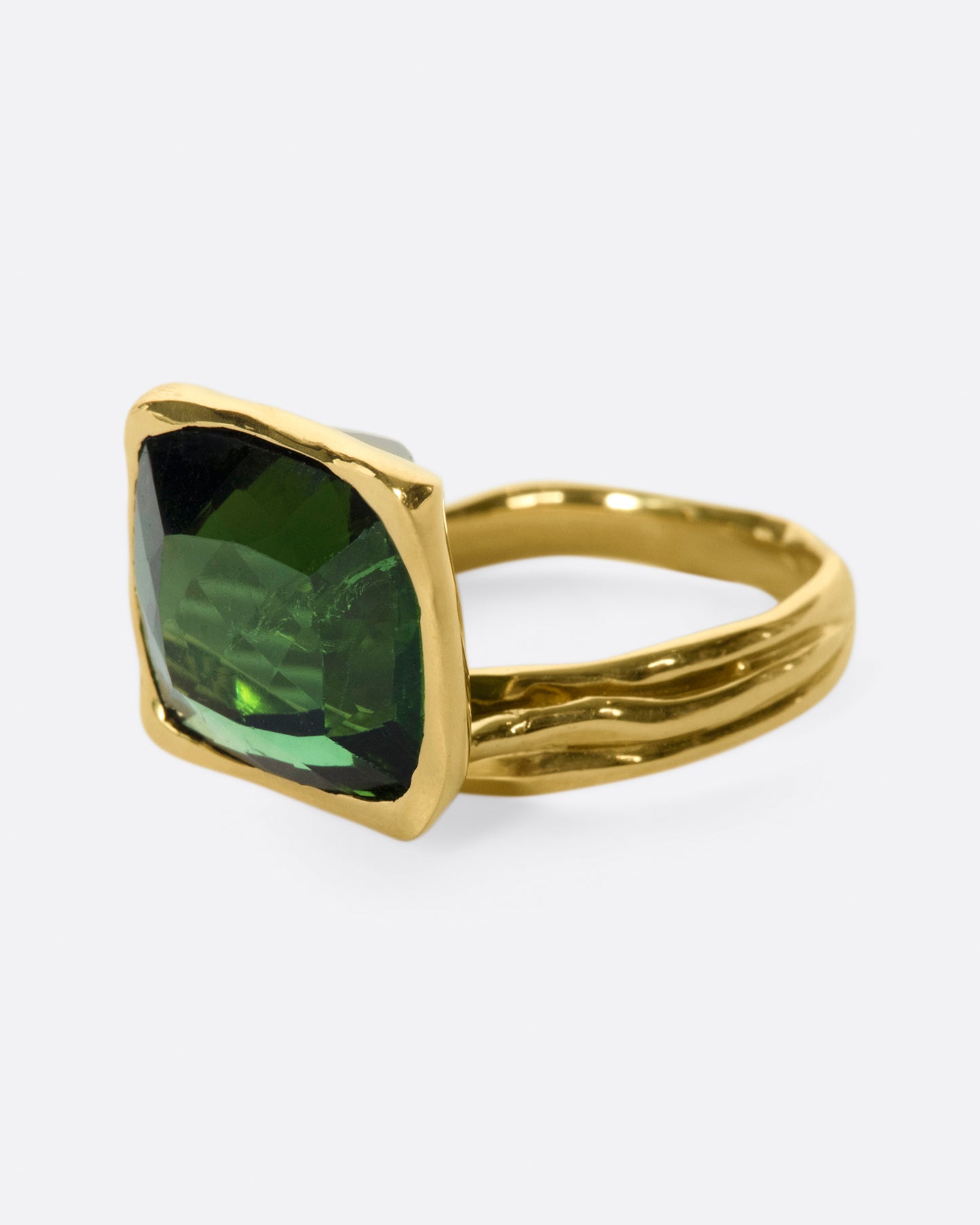 This ring is designed to showcase the tourmaline; the band is set off to one side and the setting is raised to allow for maximum light to pass through the stone.