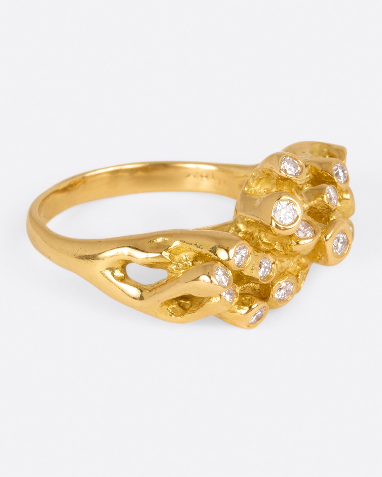 A yellow gold ring with sea anemone tentacles, dotted with diamonds, shown from side.