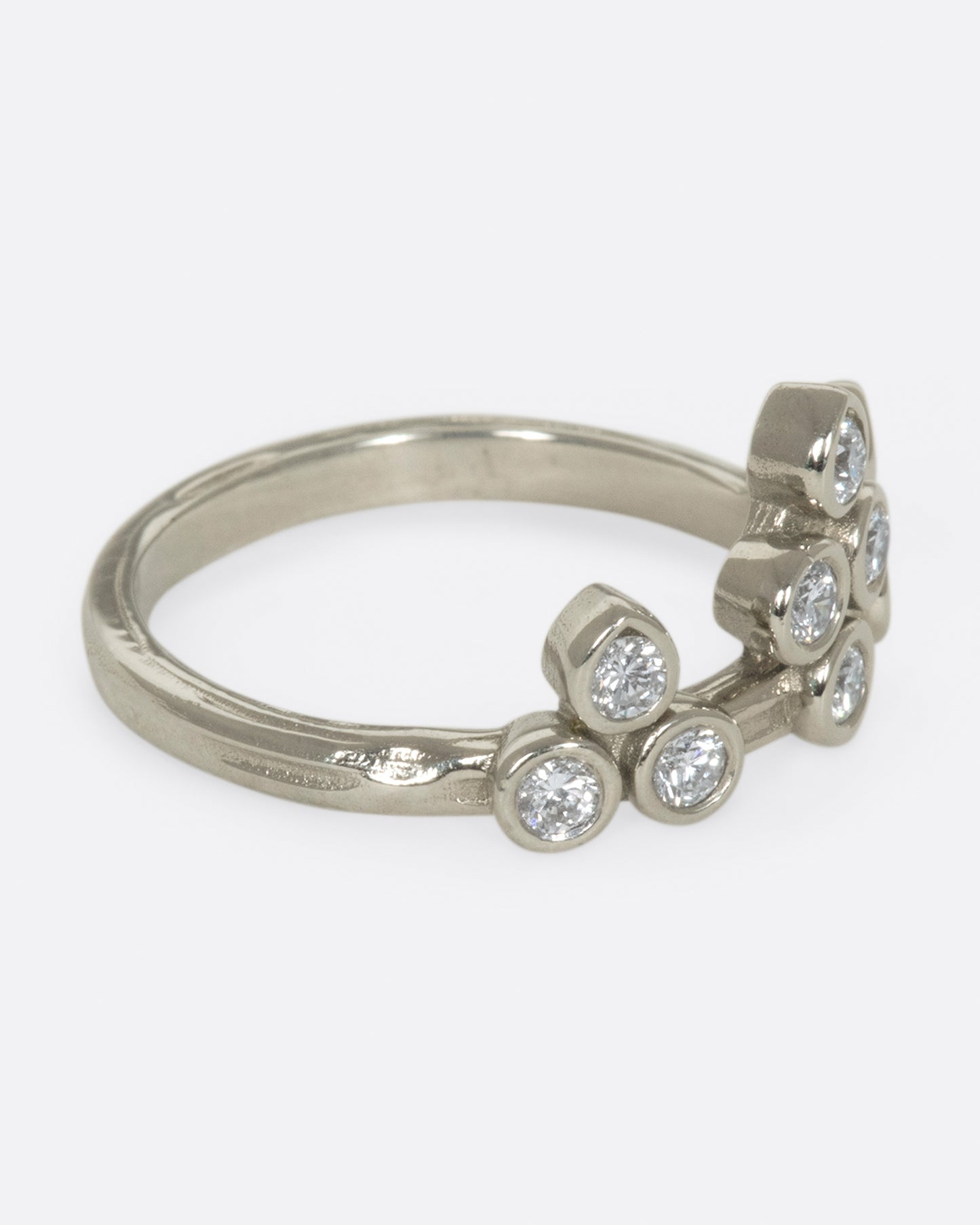 A tiara-like ring formed by 10 bezel-set round diamonds; wear it alone or stacked, and in either direction on the finger.