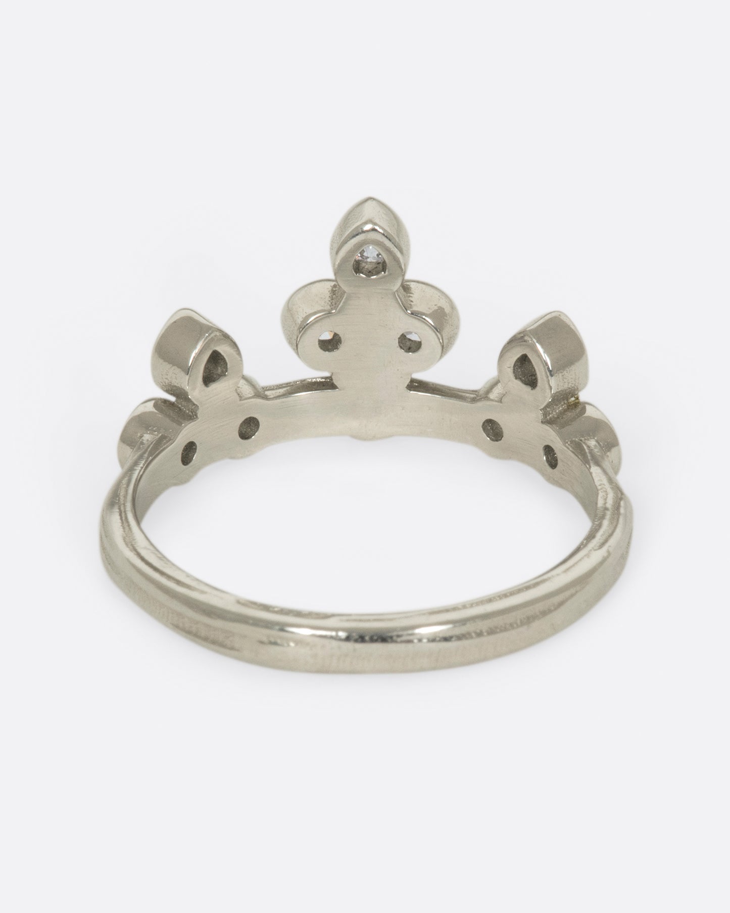 A tiara-like ring formed by 10 bezel-set round diamonds; wear it alone or stacked, and in either direction on the finger.