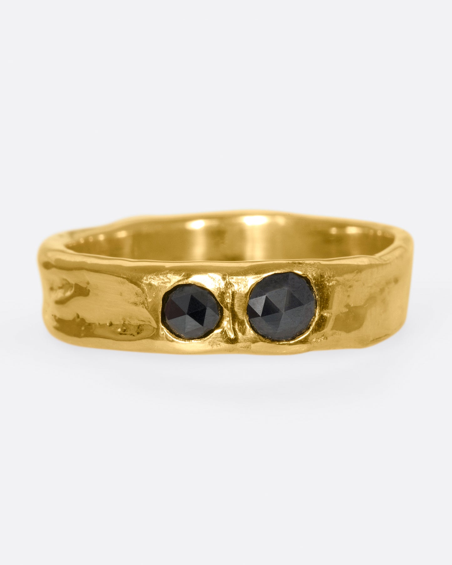 A textured band that showcases two rose cut black diamonds, set flush to the band.