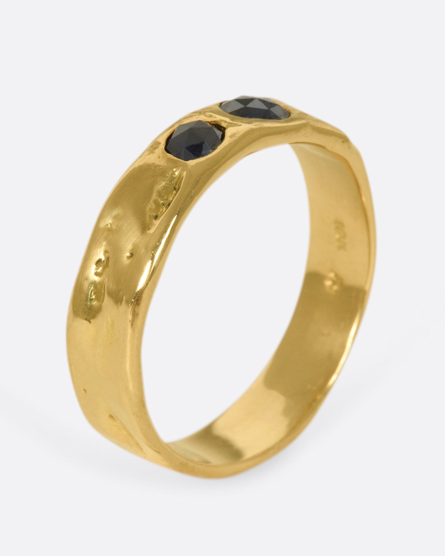 A textured band that showcases two rose cut black diamonds, set flush to the band.