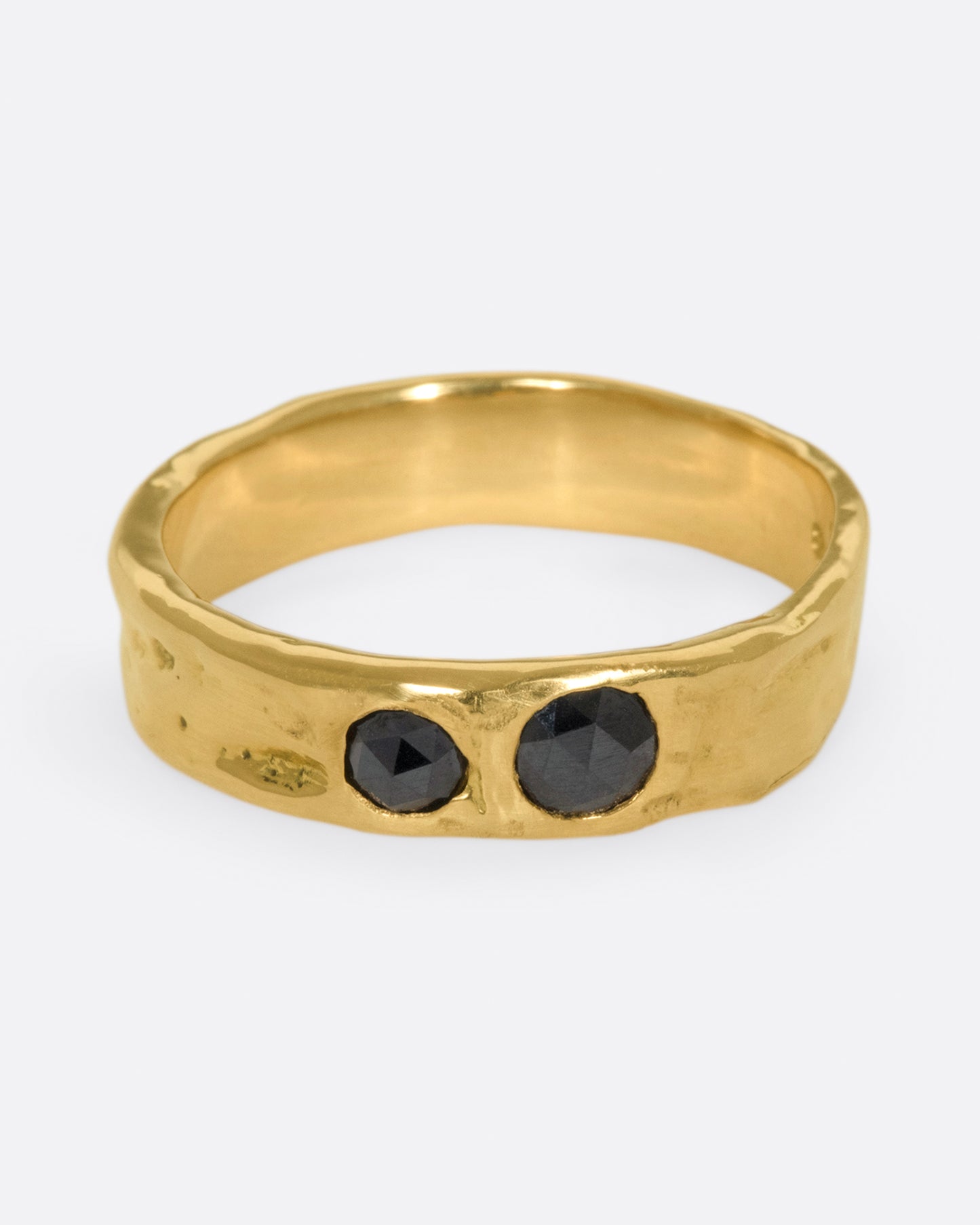 A textured band that showcases two rose cut black diamonds, set flush to the band.
