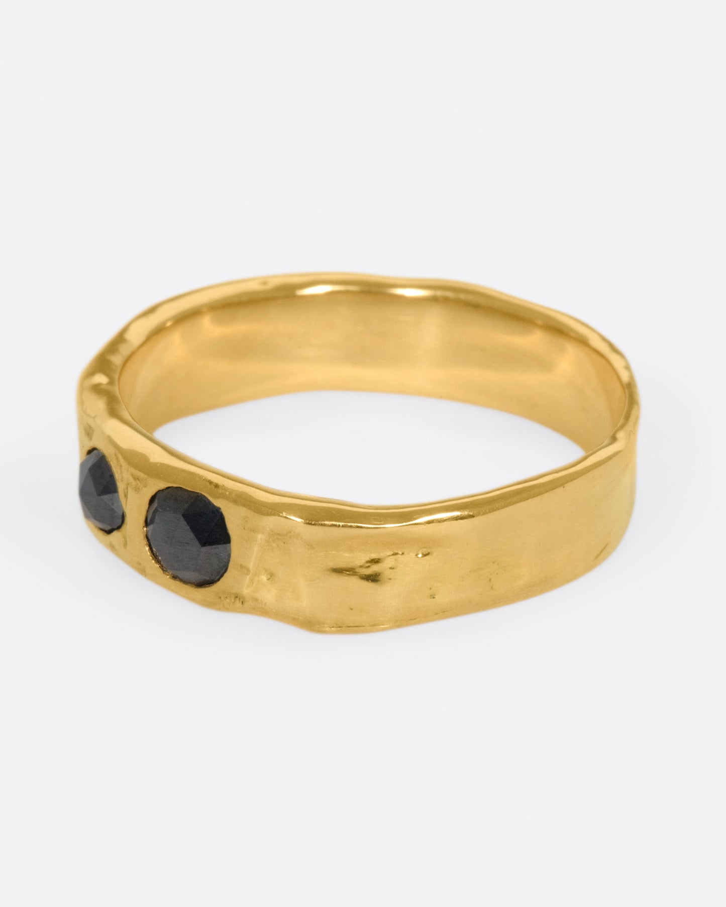 A textured band that showcases two rose cut black diamonds, set flush to the band.