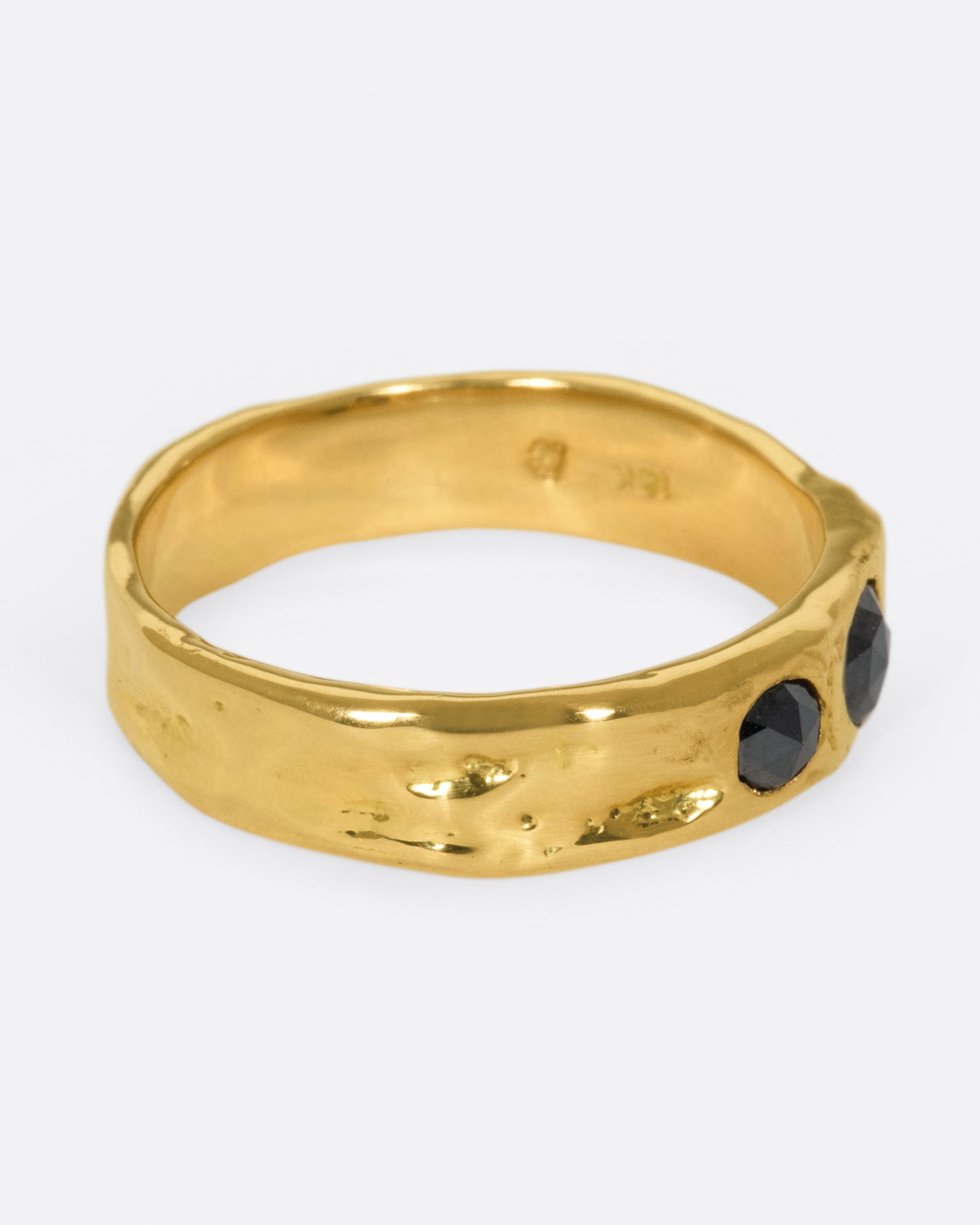 A textured band that showcases two rose cut black diamonds, set flush to the band.