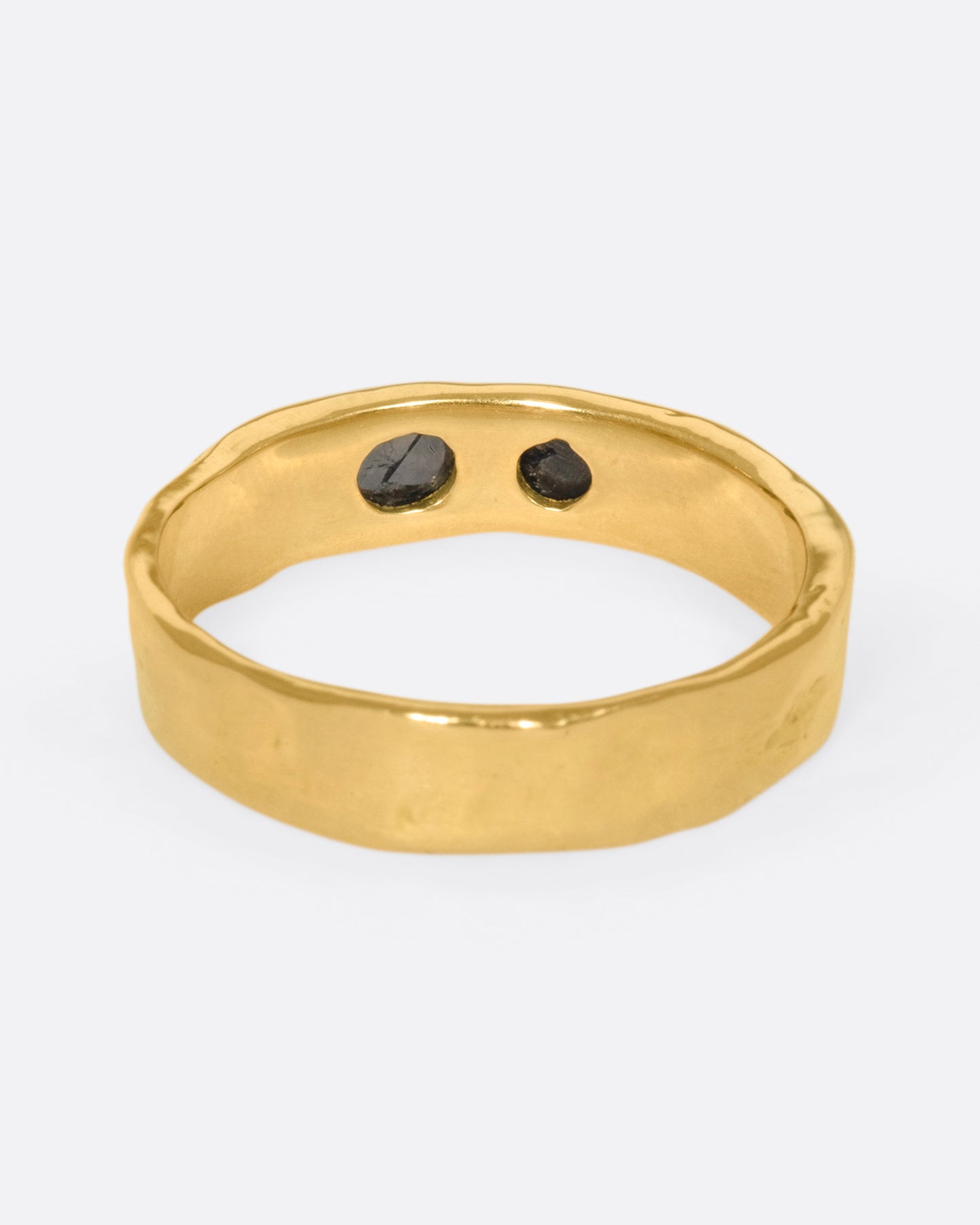 A textured band that showcases two rose cut black diamonds, set flush to the band.