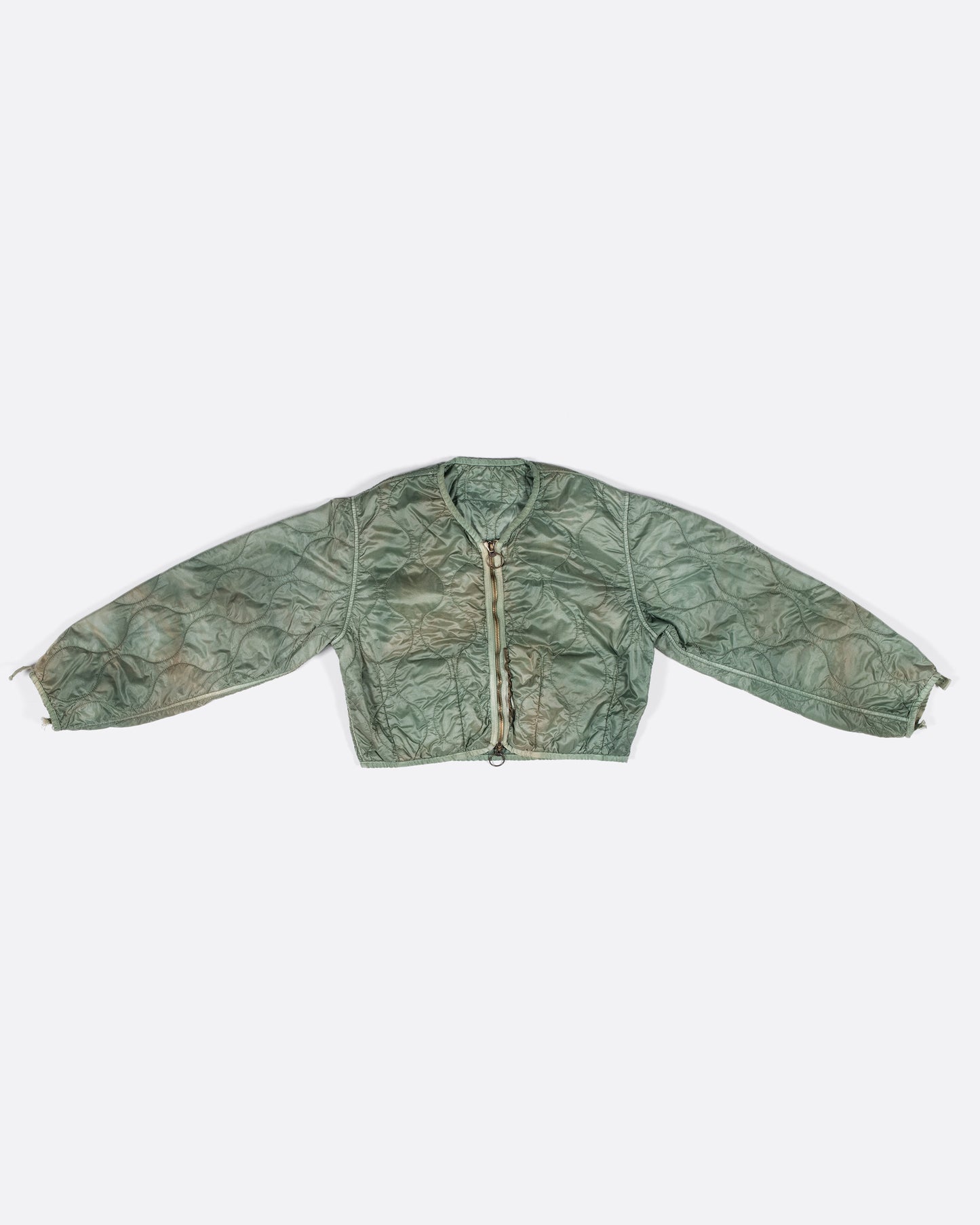A nylon, quilted, dip-dyed bolero jacket in a muted sage green - great for layering!