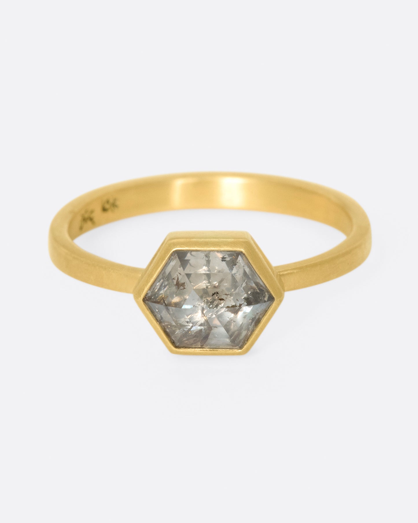 A hexagonal, faceted diamond whose colors range from shades of brown to gray