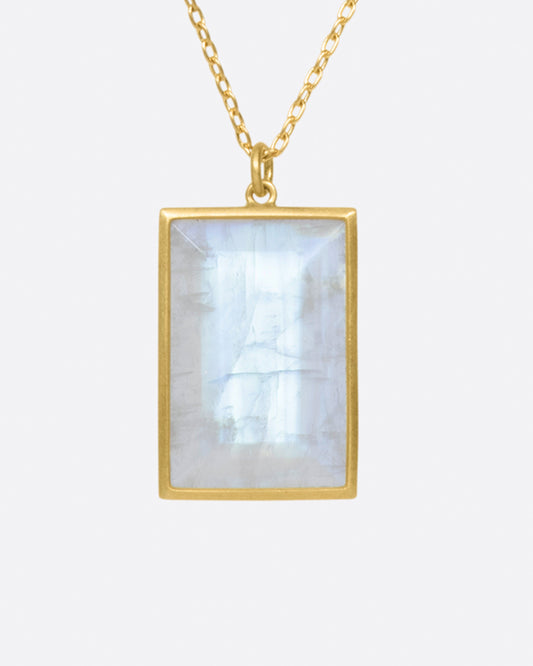 A large rainbow moonstone glows in a narrow matte gold bezel on this pendant necklace.