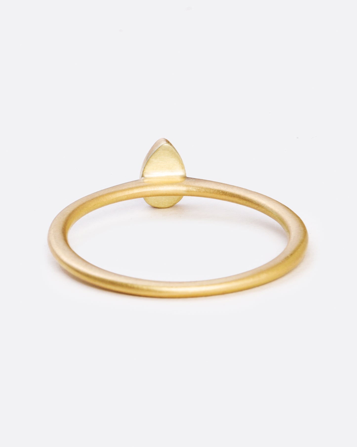 A yellow gold ring with a bezel set teardrop shaped diamond. Shown from the back.