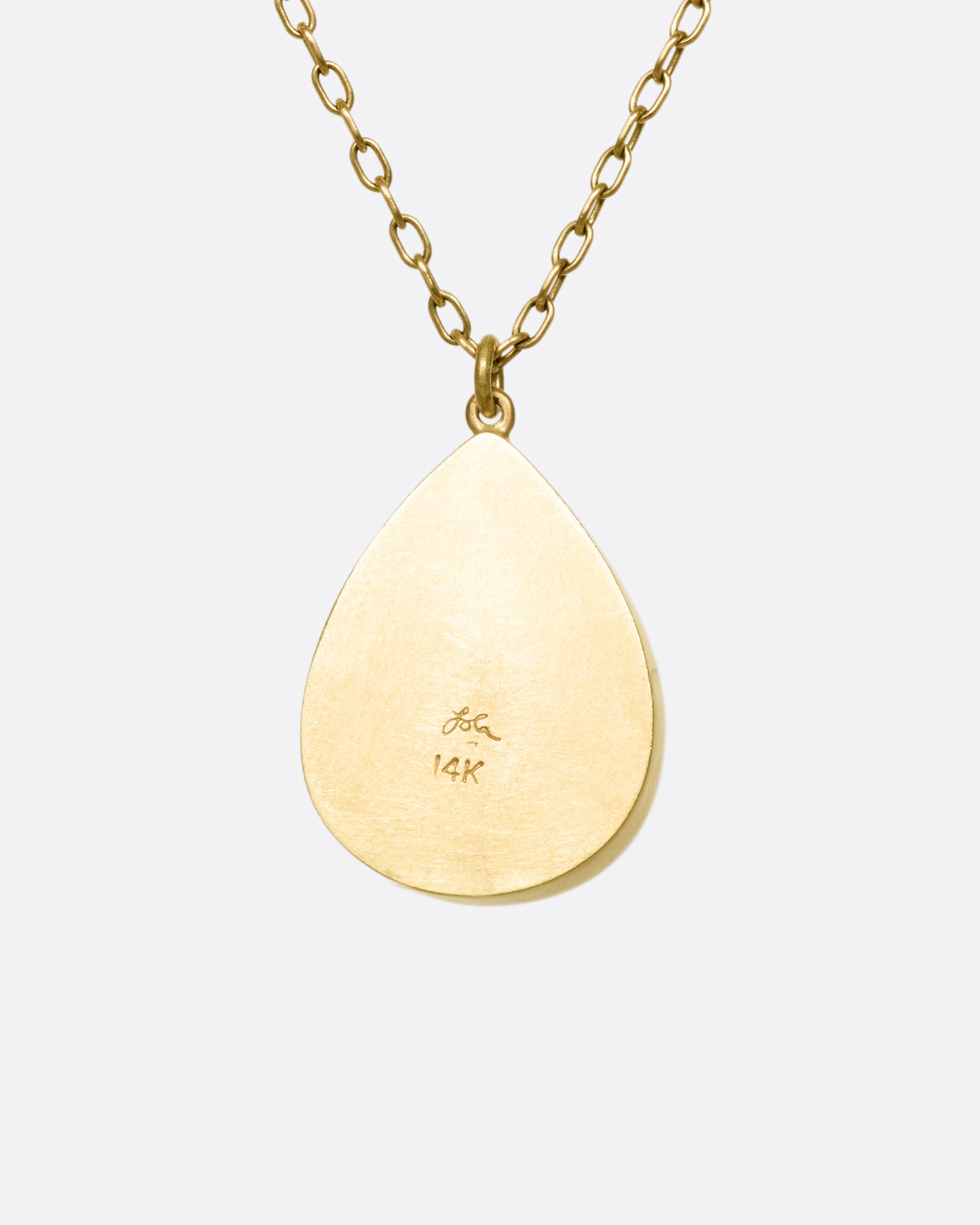 A gold necklace with a quartz crystal teardrop pendant.