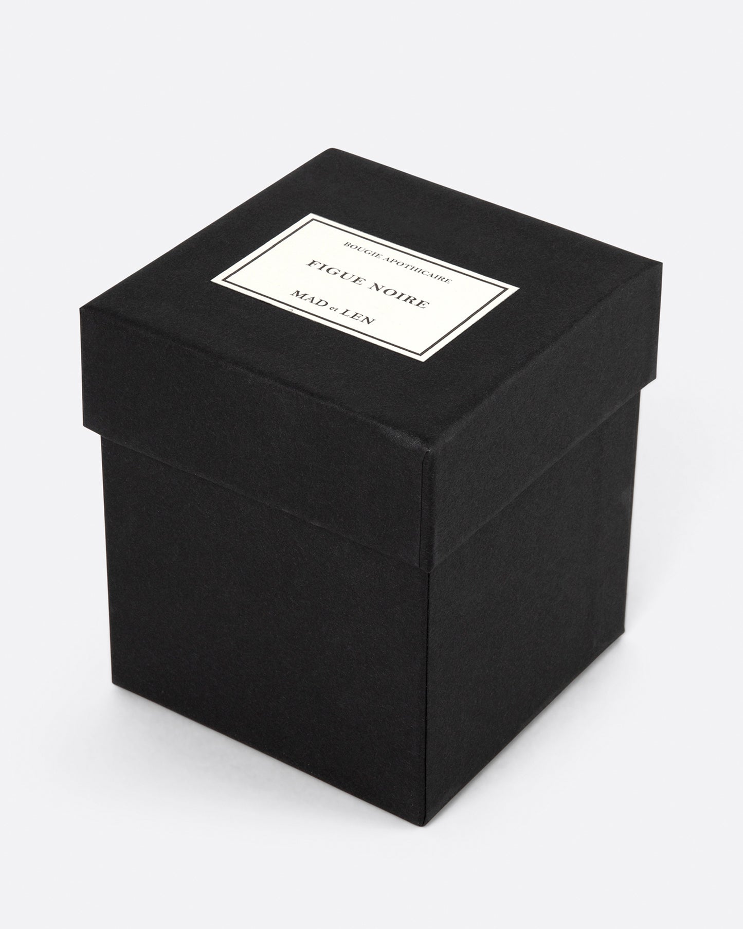 A square black Mad et Len Figue Noire candle box shown from the side at an angle.