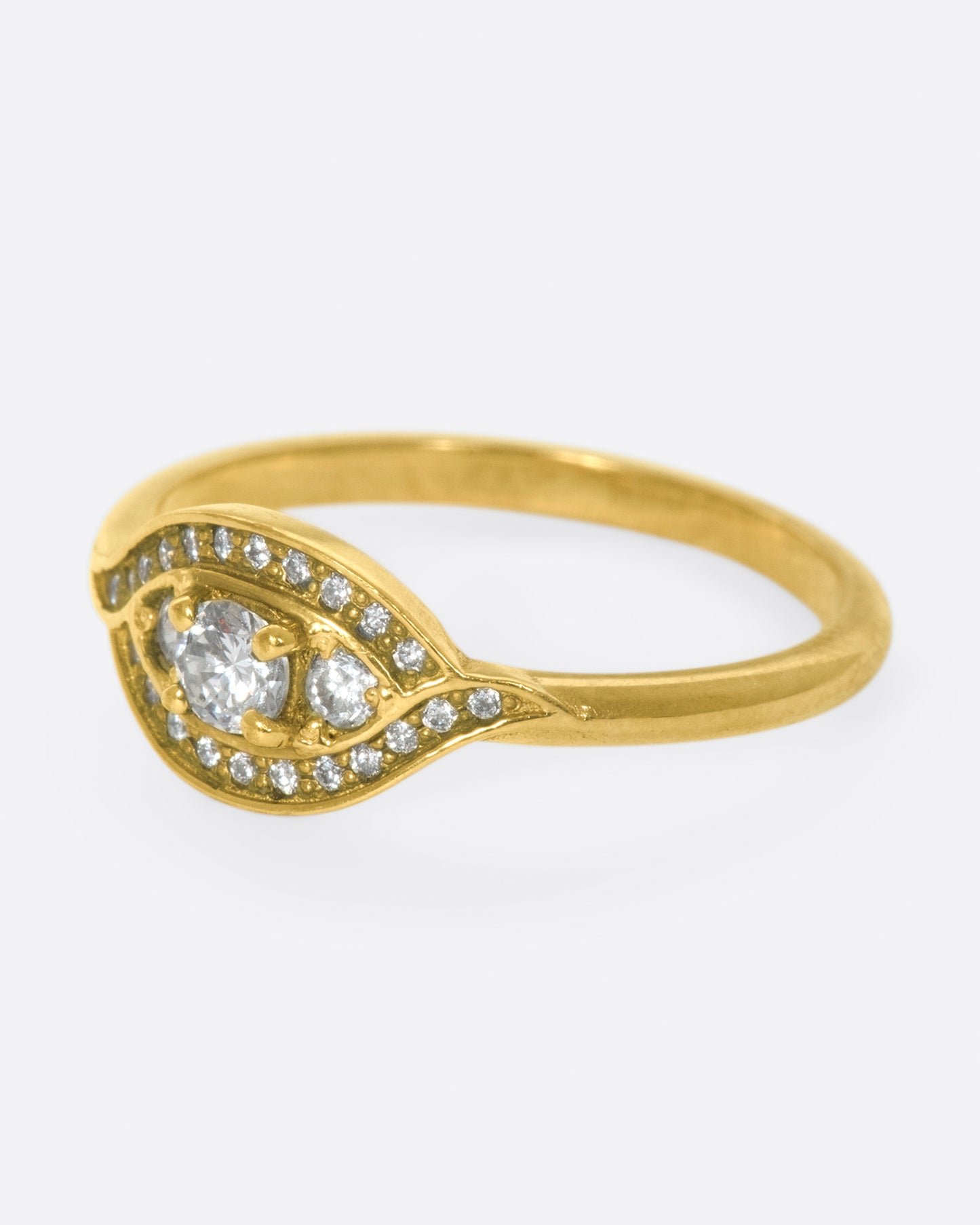 Two waves of pavé diamonds surround three rose cut white diamonds on this low profile ring