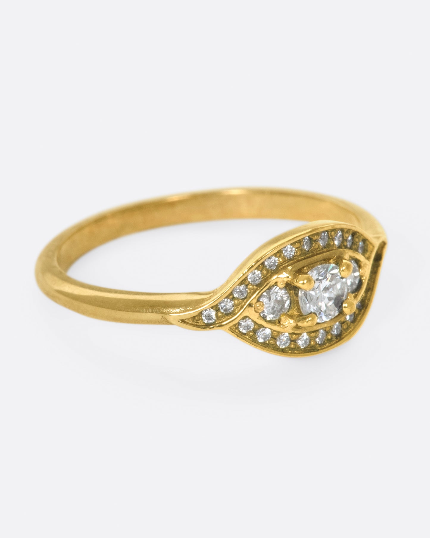 Two waves of pavé diamonds surround three rose cut white diamonds on this low profile ring