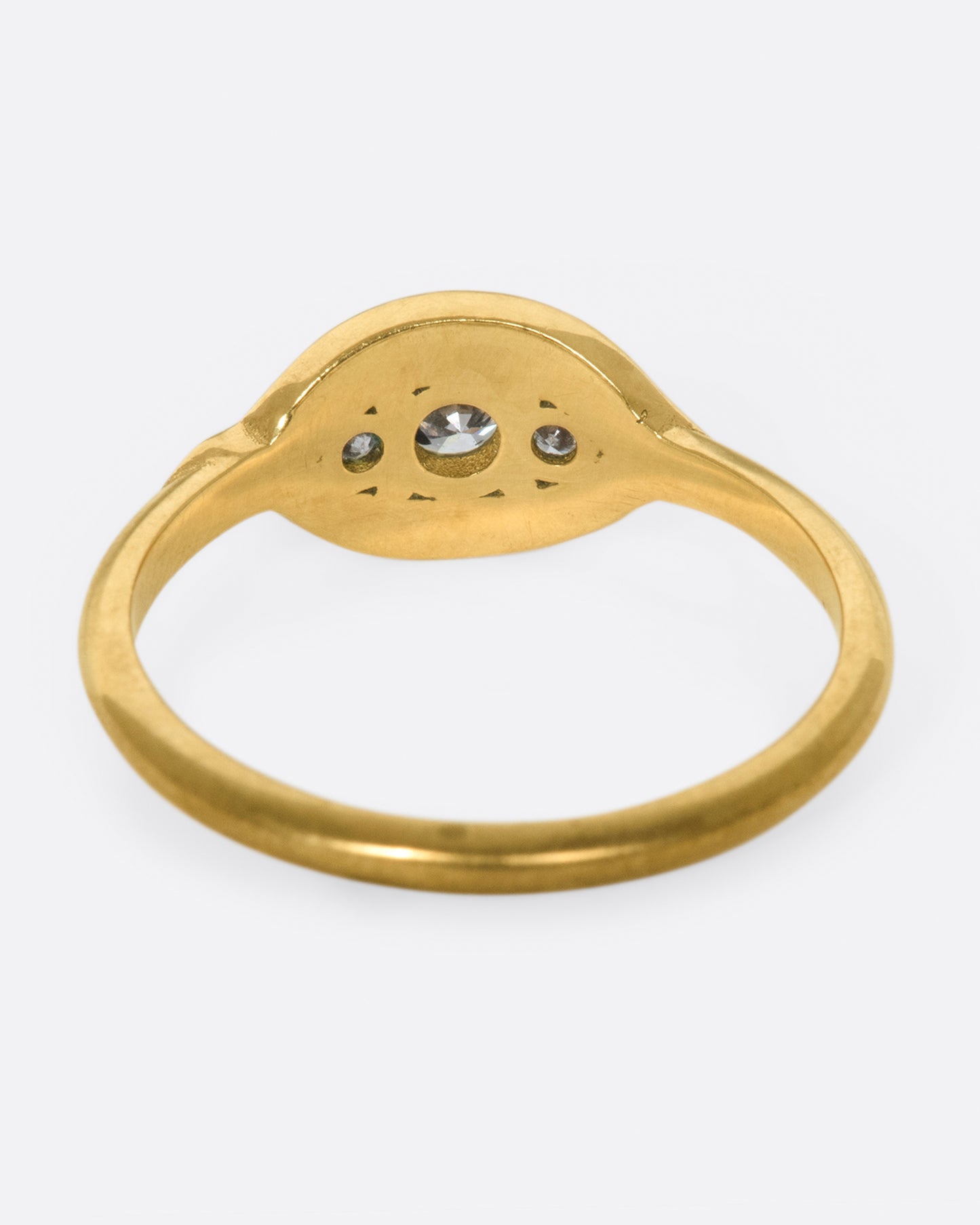 Two waves of pavé diamonds surround three rose cut white diamonds on this low profile ring