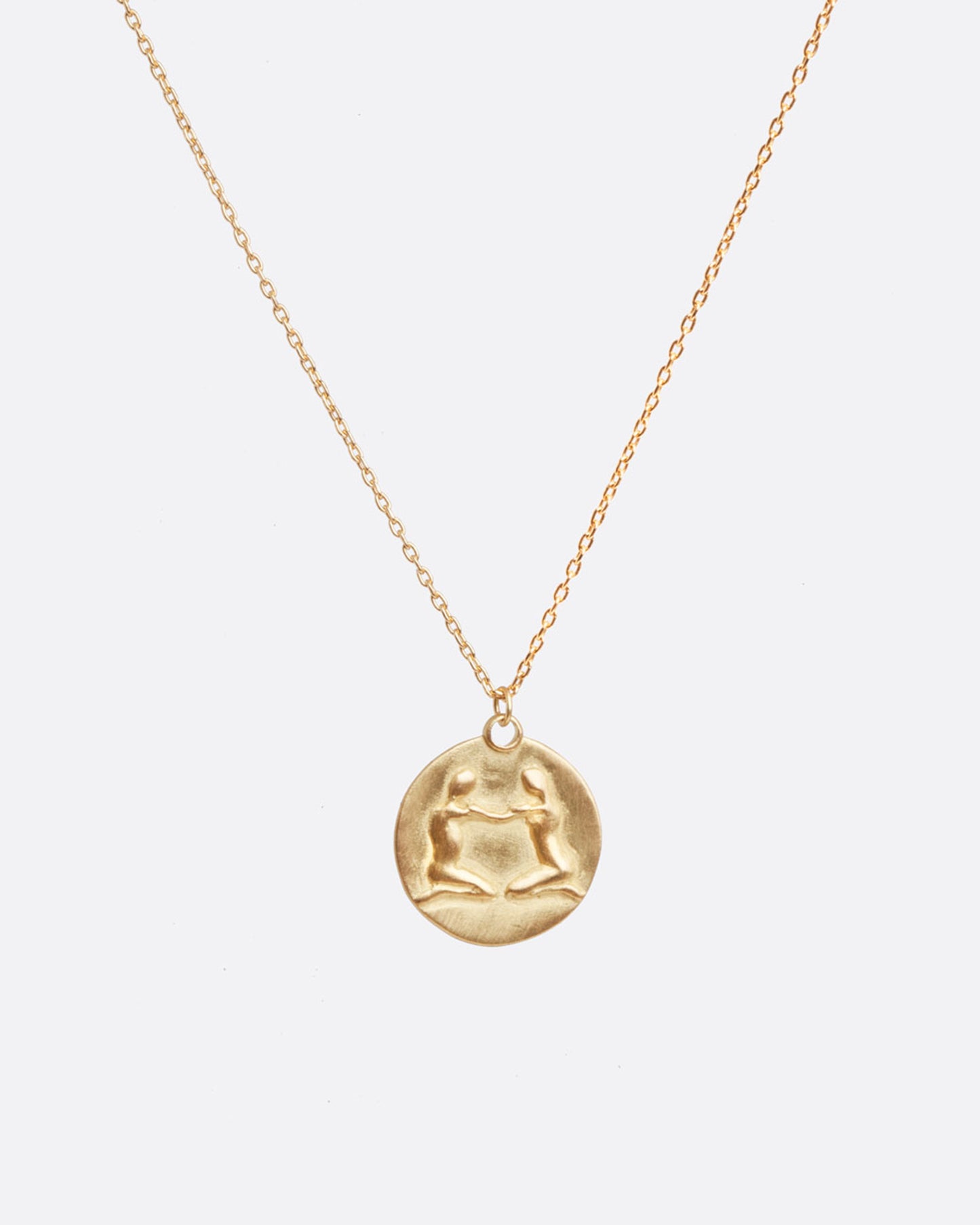 A yellow gold necklace with a round pendant with your choice of zodiac symbol.