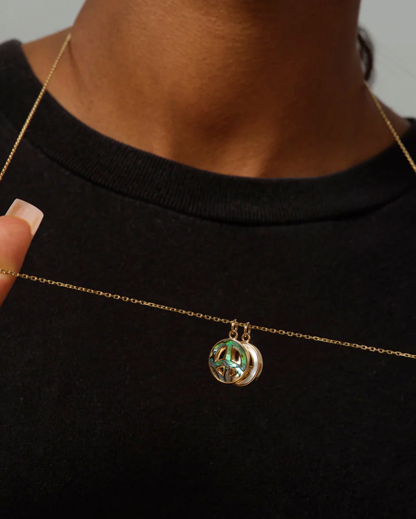 Abalone and mother of pearl peace sign pendants on a long, diamond cut chain.