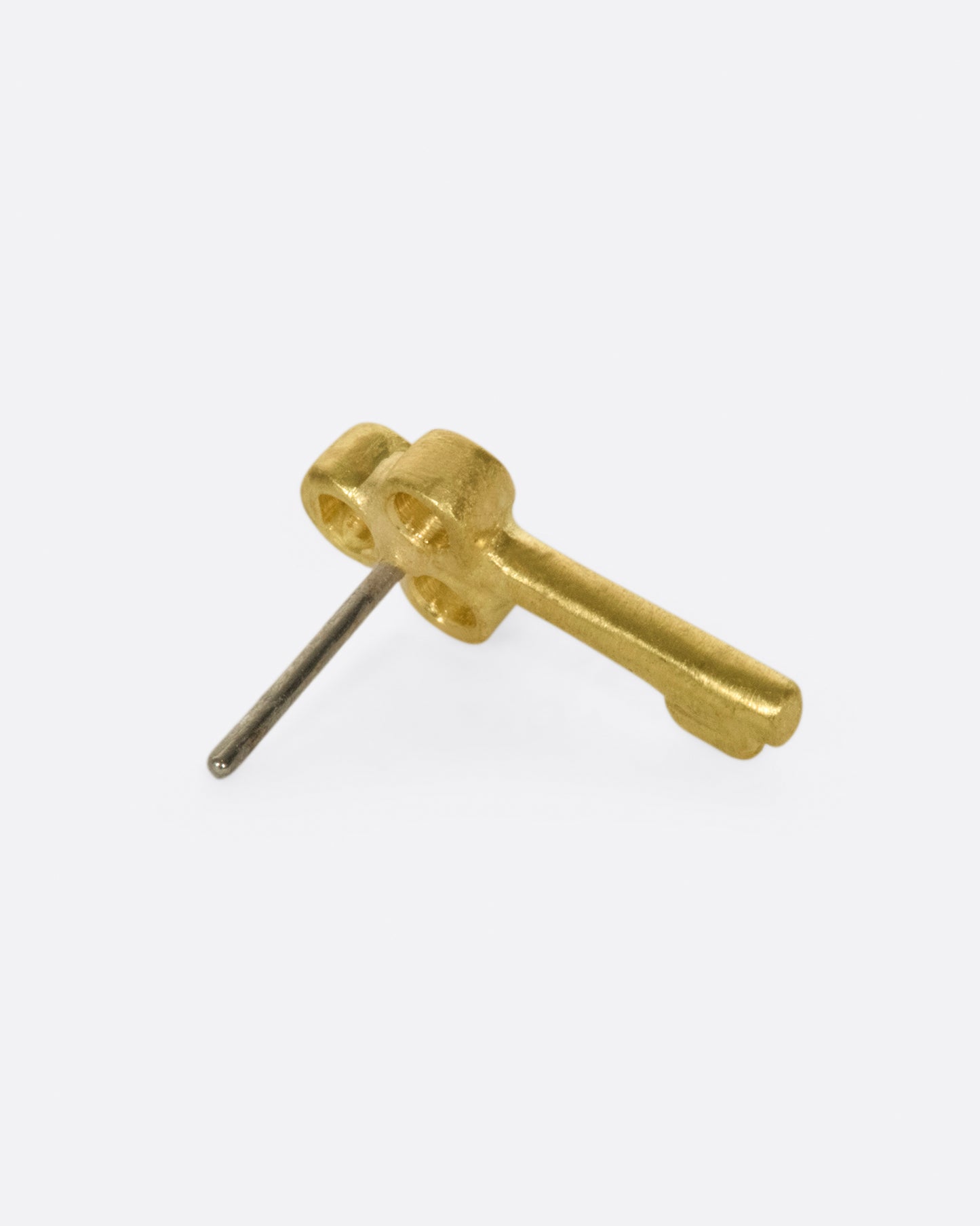 A tiny, matte gold key to adorn your ear.
