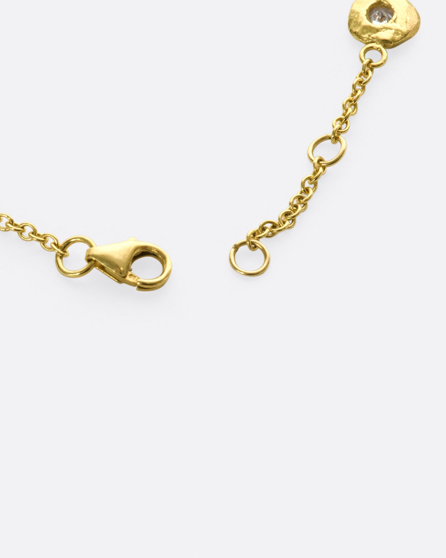 A handmade take on a classic style; this chain bracelet has five diamonds set in hand carved bezels, a bit over an inch apart.