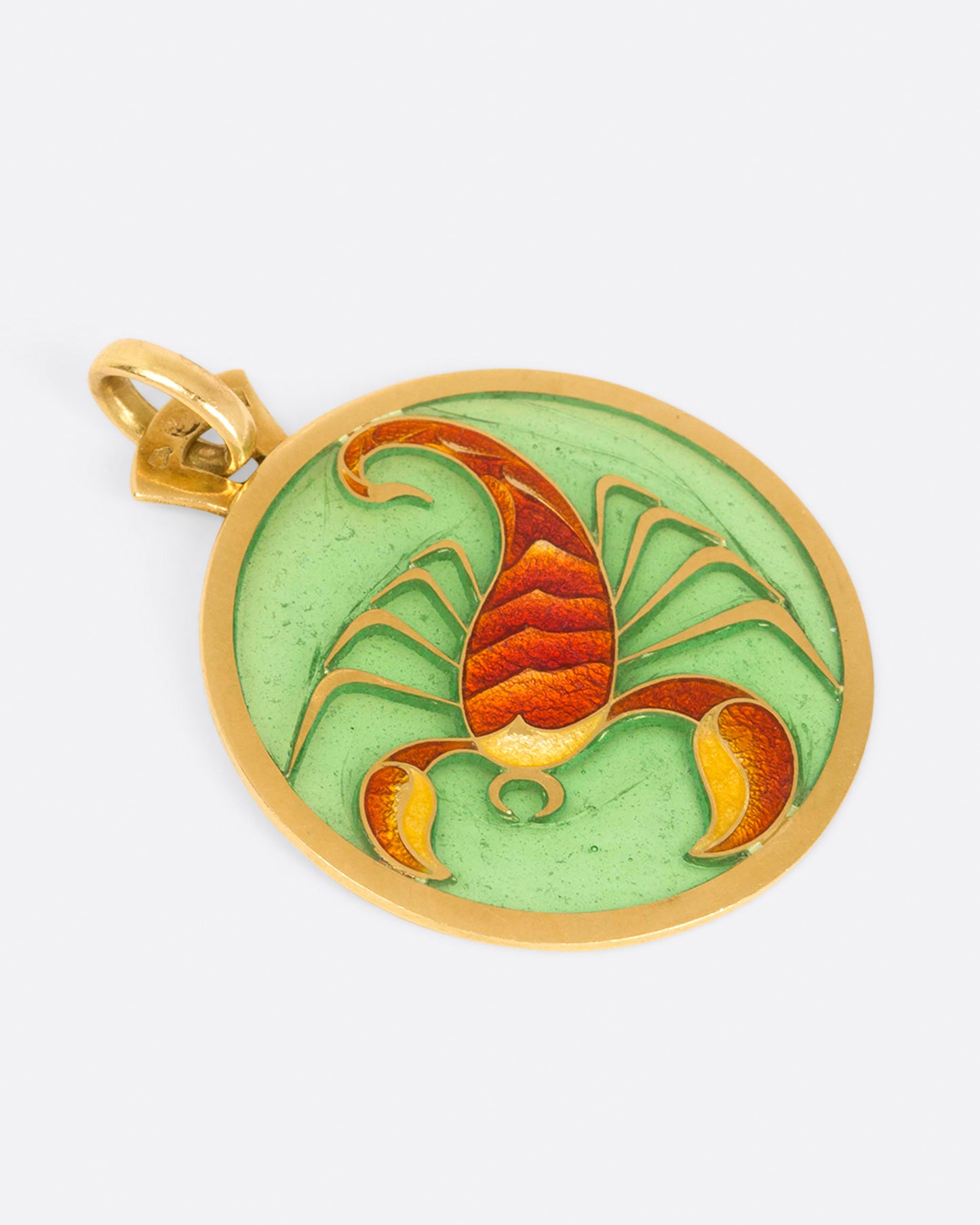 Round gold and enamel plique-a-jour pendant with a scorpion, shown from the side.