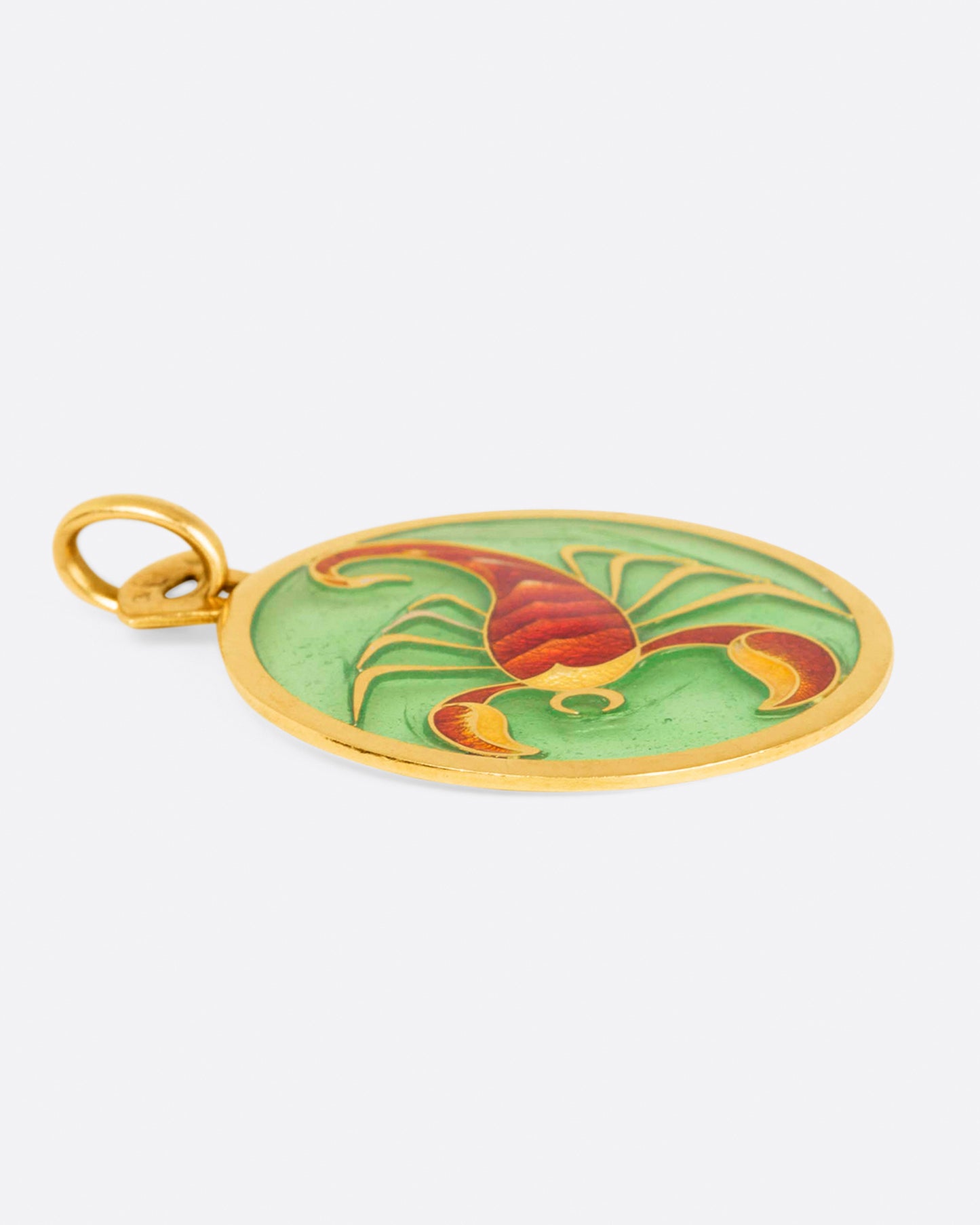 Round gold and enamel plique-a-jour pendant with a scorpion, shown from the side.