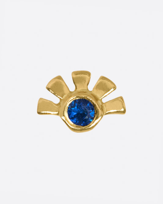 A deep blue sapphire with gold rays around one side.