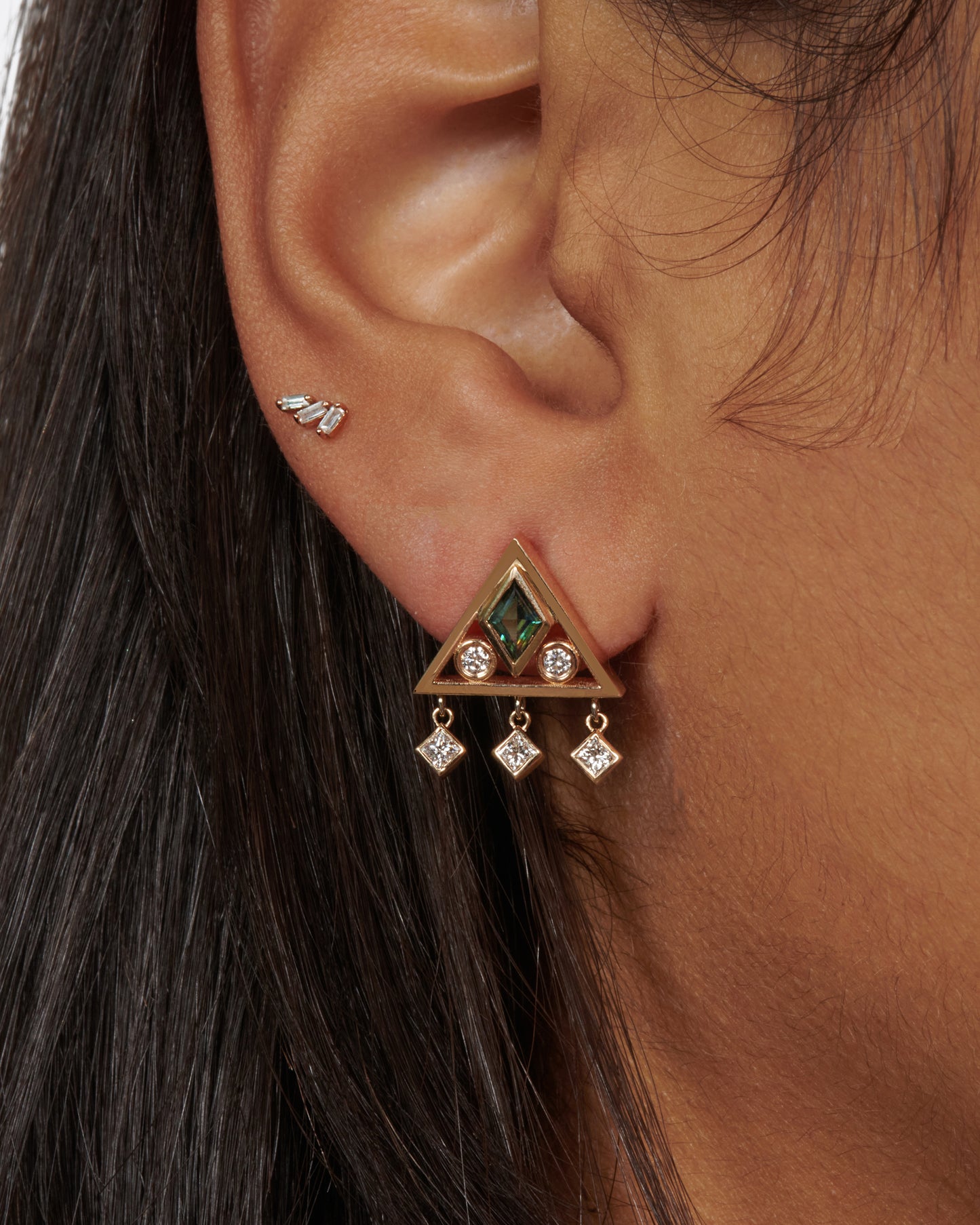 A gorgeously geometric pair of 14k gold triangle studs with teal sapphire lozenges and diamond accents