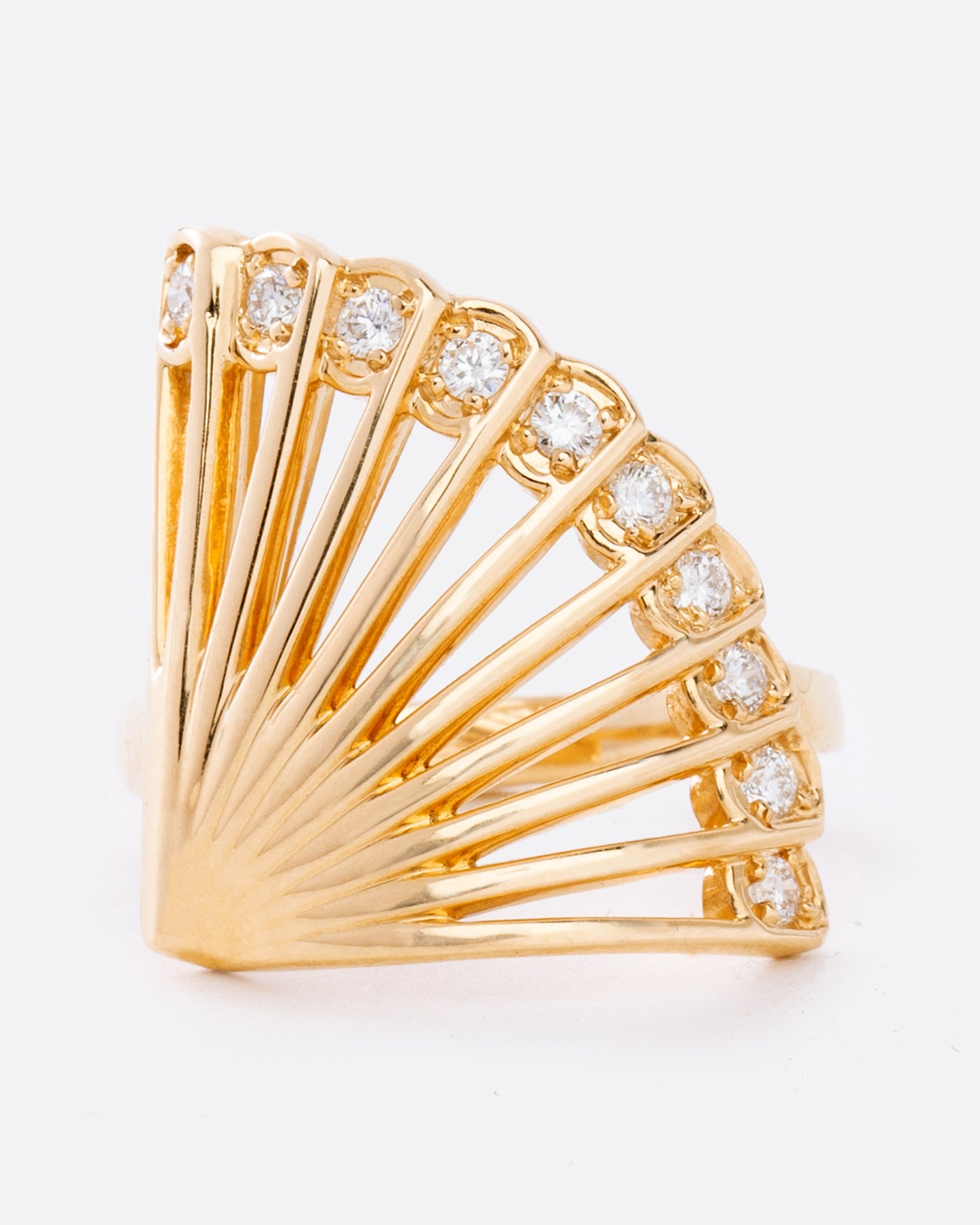 A yellow gold ring in the shape of a fan with diamonds along the top edge. Shown from the front.