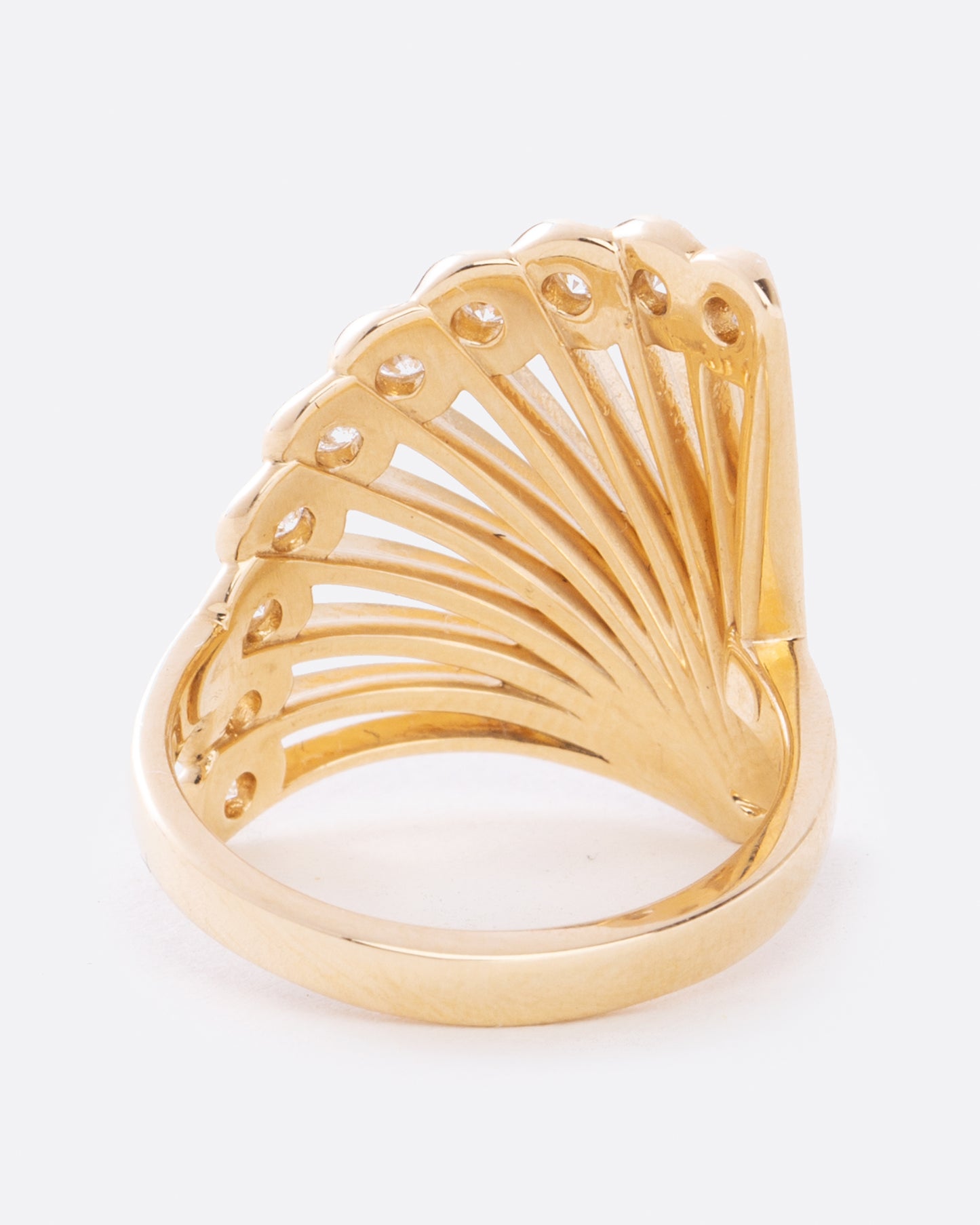 A yellow gold ring in the shape of a fan with diamonds along the top edge. Shown from the back.