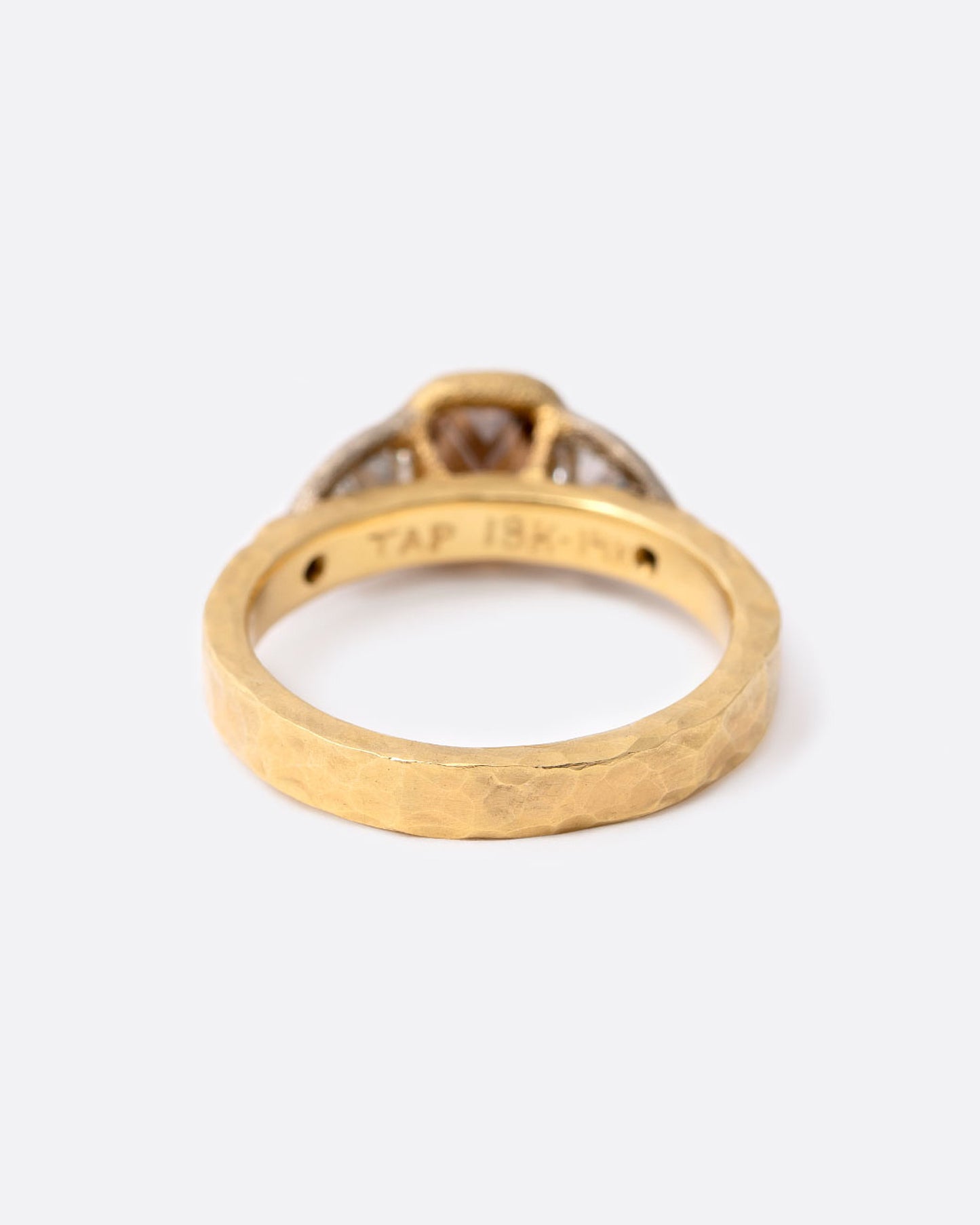 A yellow gold ring with a cushion cut cognac diamond at the center flanked by two shield cut diamonds and two smaller round cognac diamonds. Shown from the back.