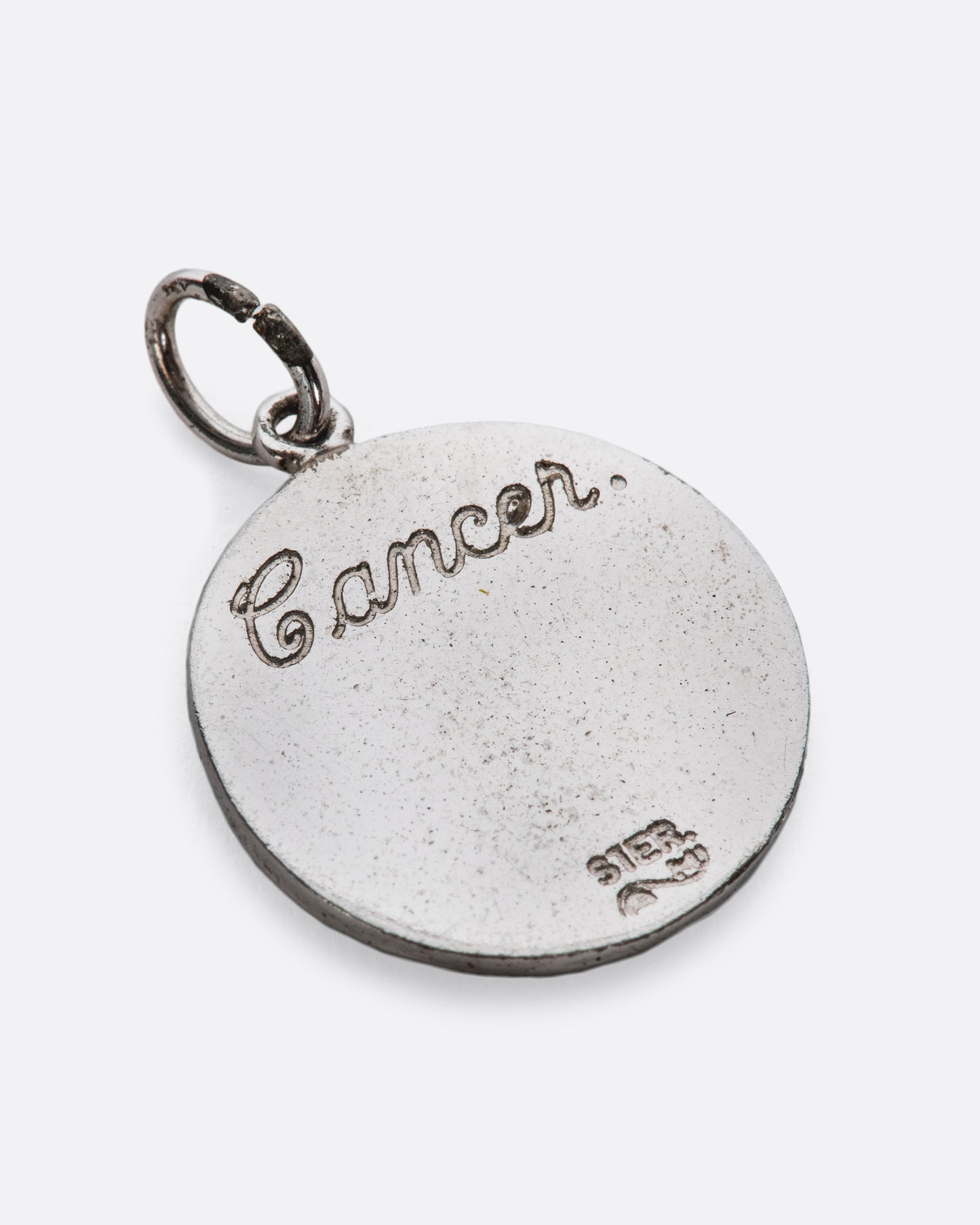 A textured medallion with a smooth, engraved backside.