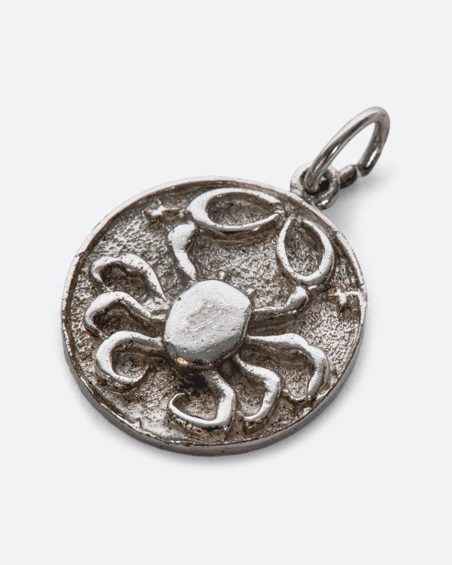 A textured medallion with a smooth, engraved backside.