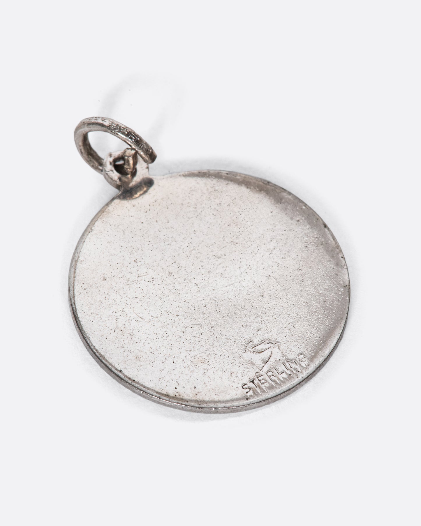 An engine turned pendant featuring the lion and Leo dates.