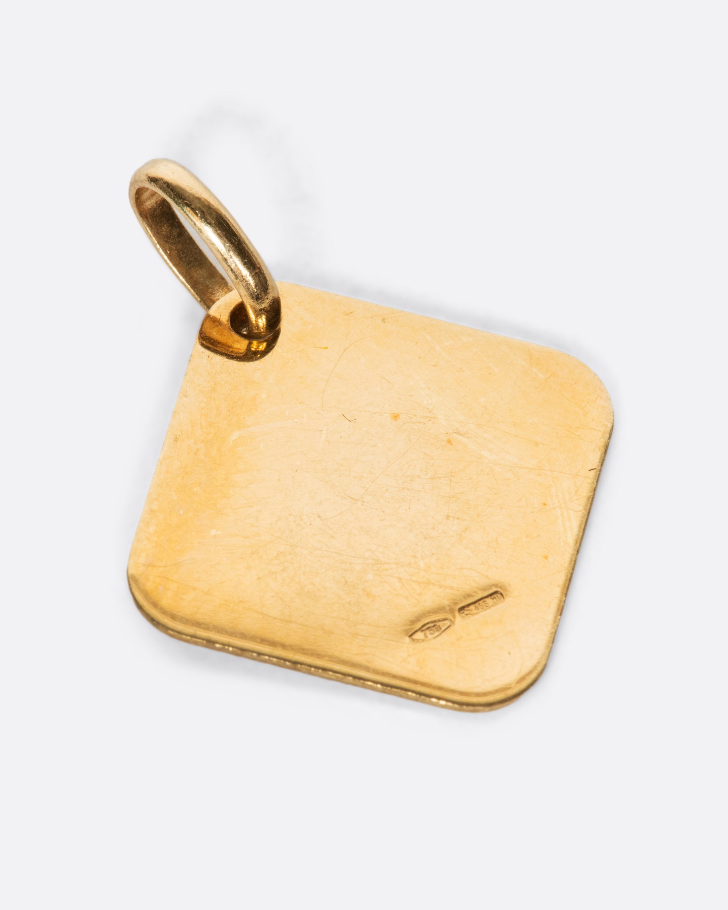 A square, polished pendant, hung by one of its corners.