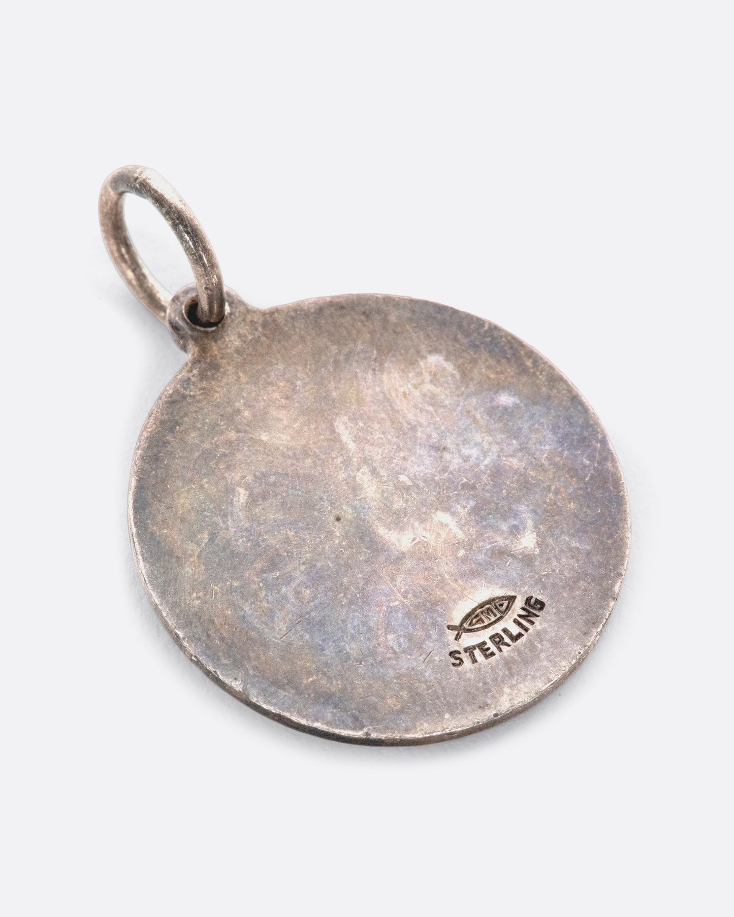 An engine turned pendant featuring the virgin goddess and Virgo symbol.