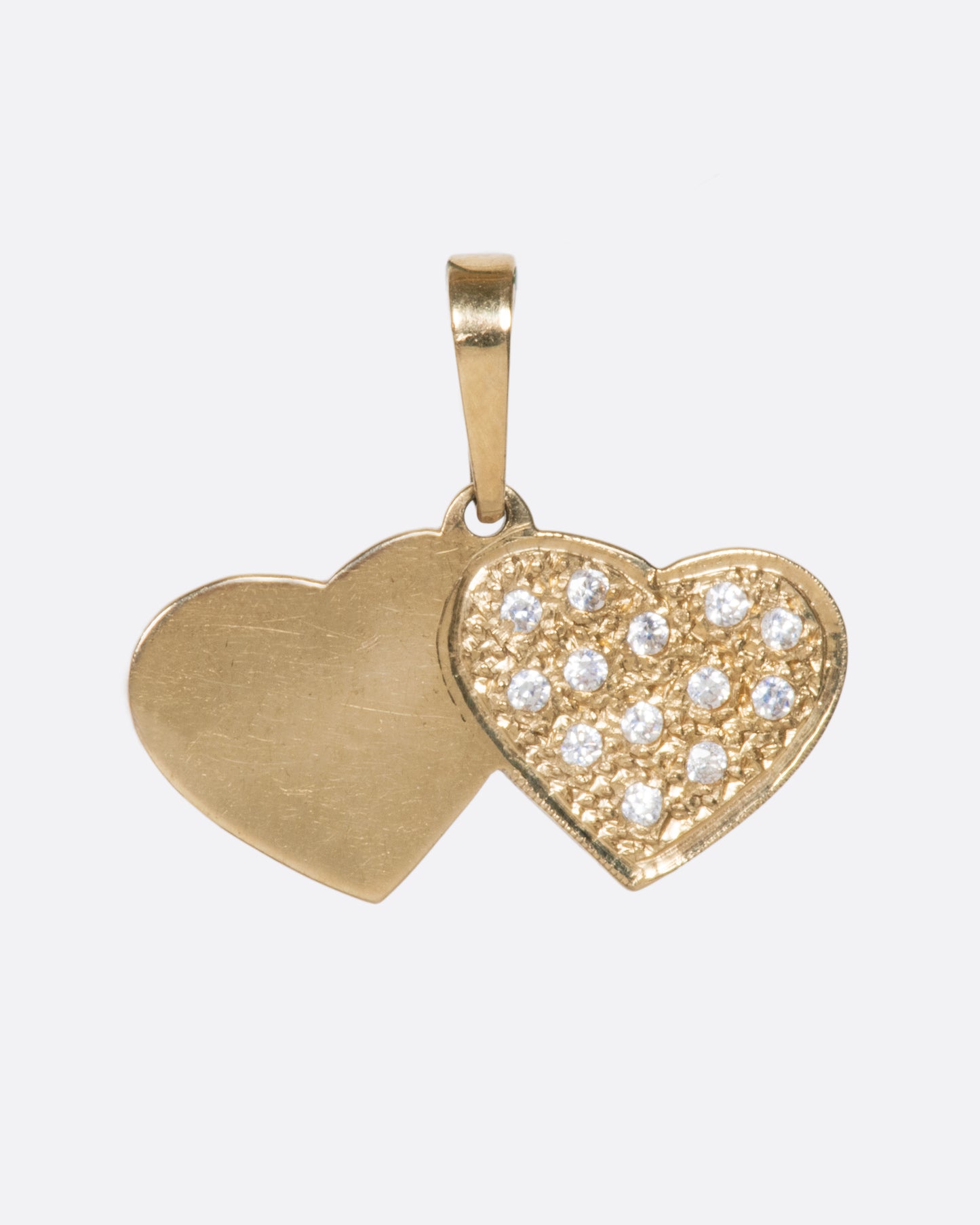 A vintage double heart charm with pavé diamonds over a stipple finish, adding extra shine between the stones.