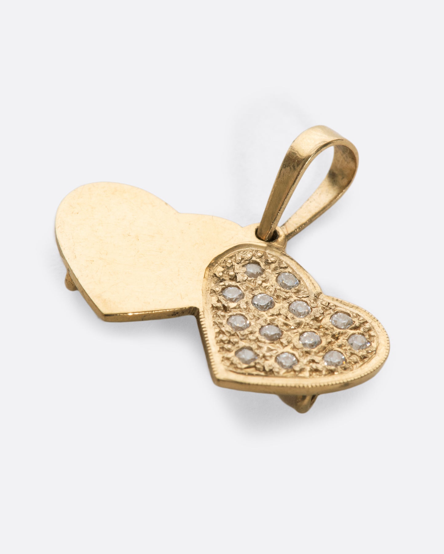 A vintage double heart charm with pavé diamonds over a stipple finish, adding extra shine between the stones.