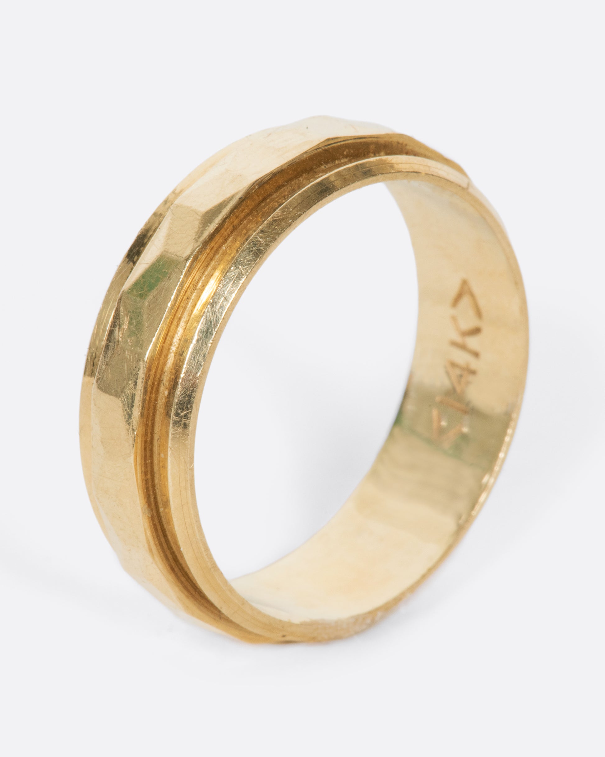A vintage yellow gold band with geometric faceting down the center.