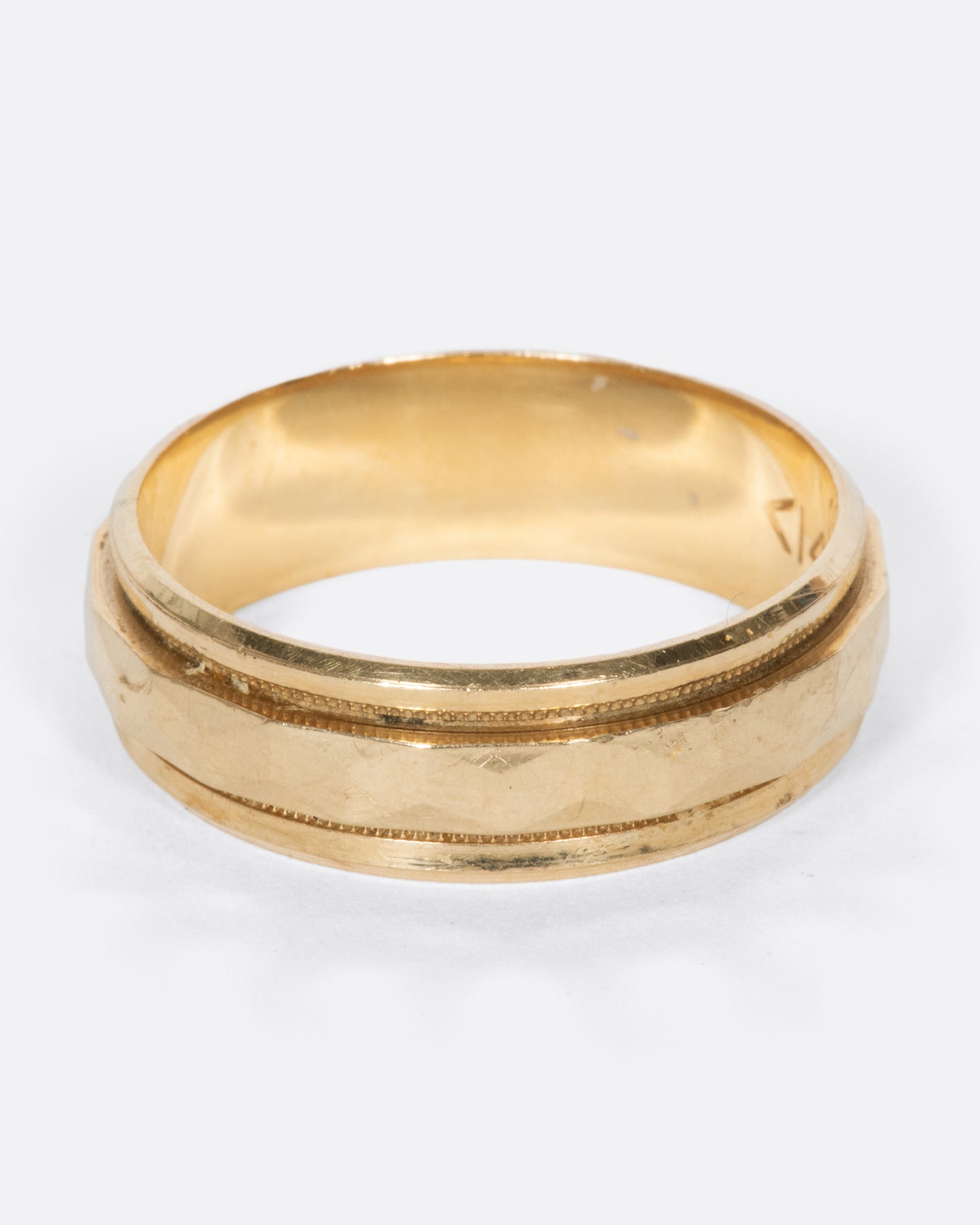 A vintage yellow gold band with geometric faceting down the center.