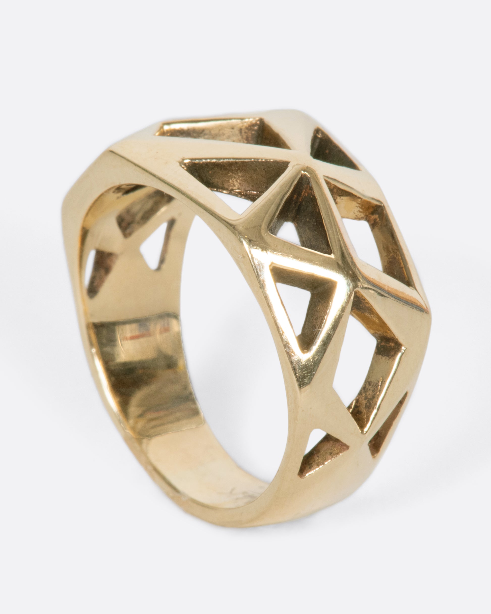 A vintage yellow gold ring with a raised, faceted face that has geometric cutouts throughout.